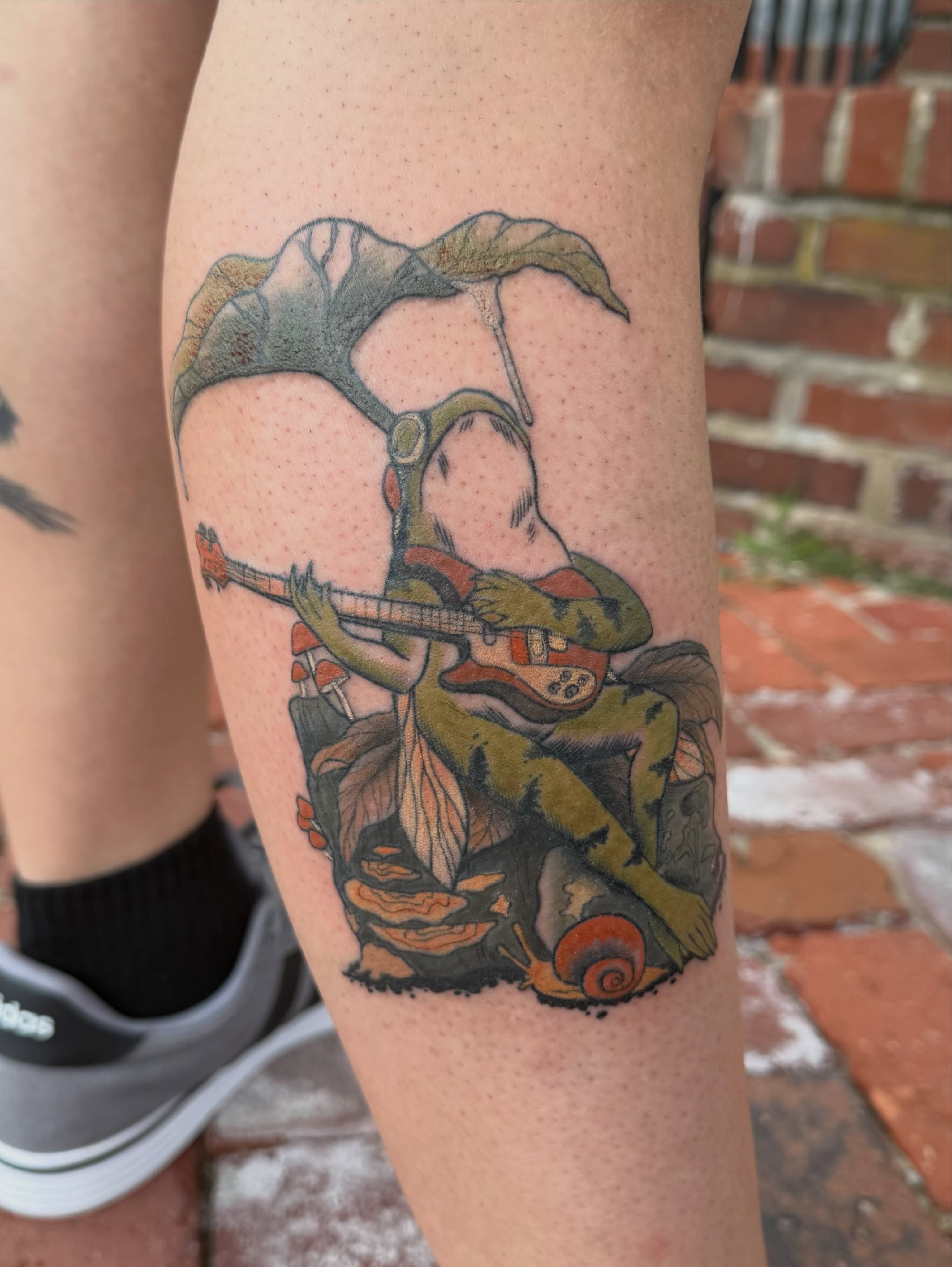 Frog playing guitar illustrative tattoo on the forearm by Bri ⚡️✨
