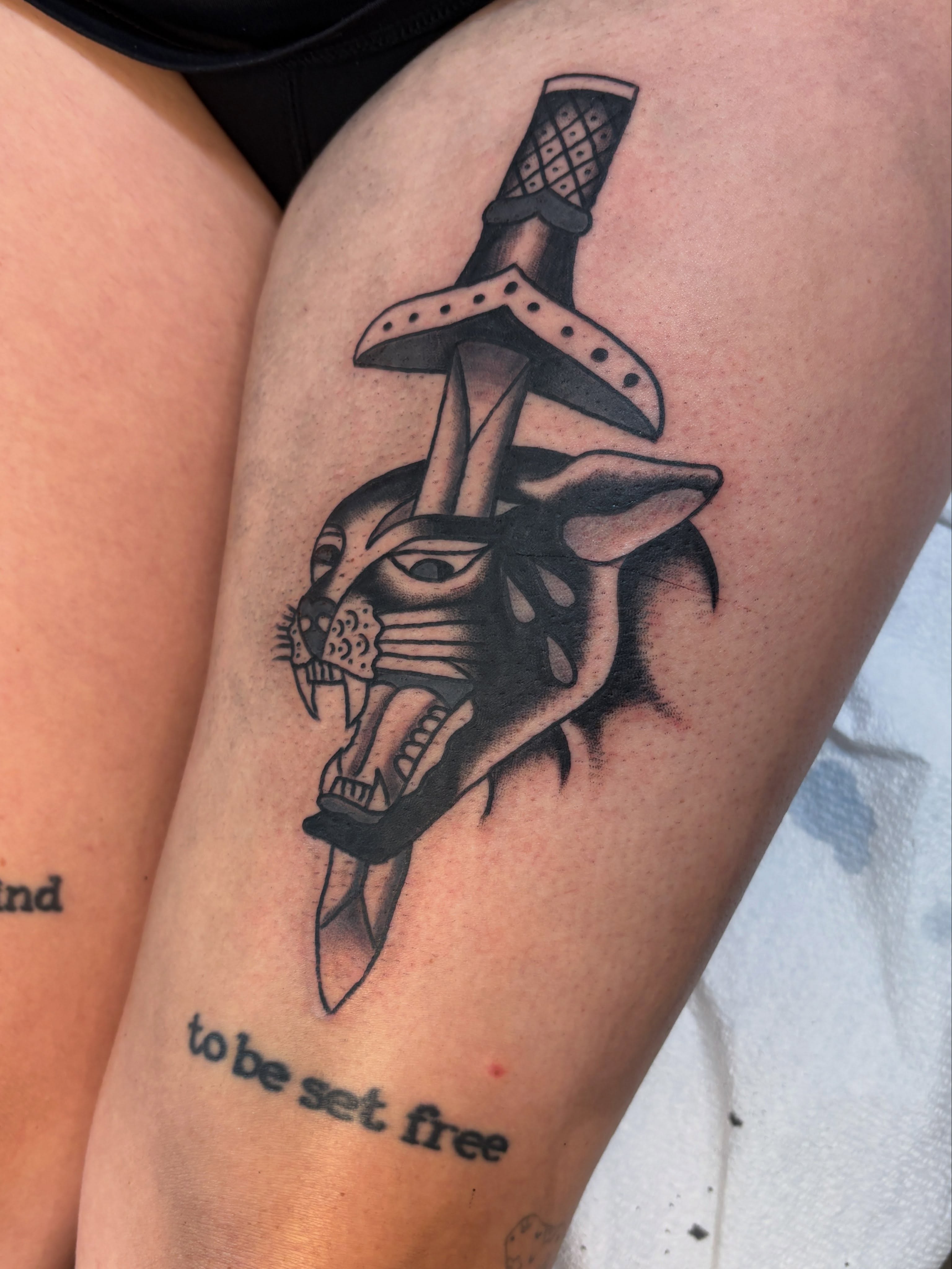 Panther head with sword black and grey tattoo on the thigh by Sammy Tattoo, Austin, Texas