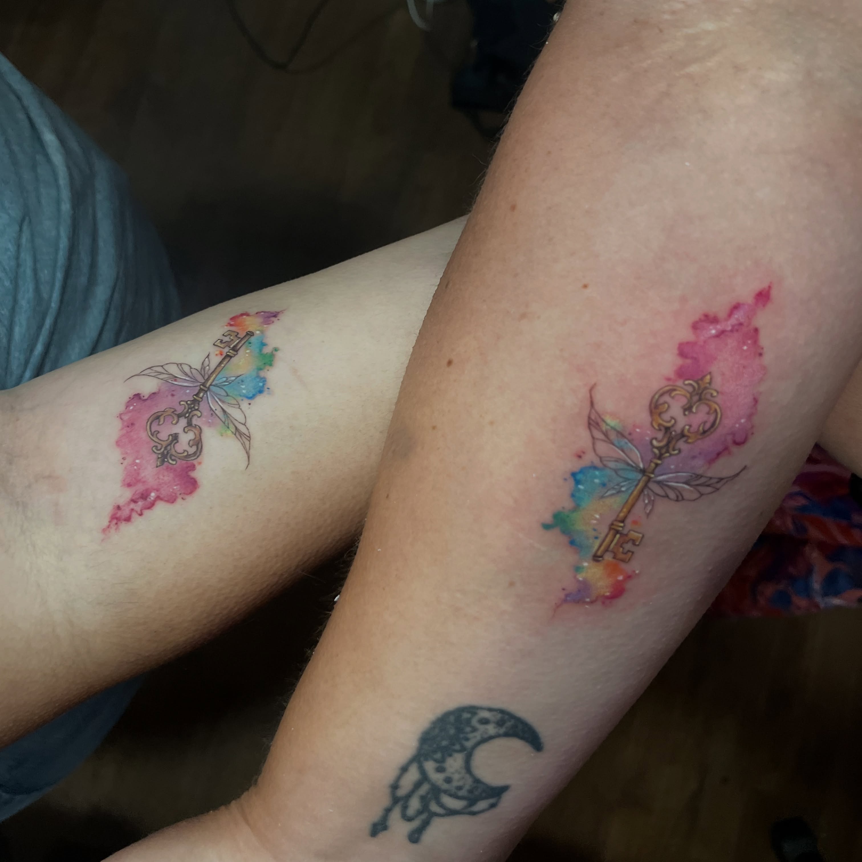 Key with butterfly watercolor tattoo on the forearm by SJ