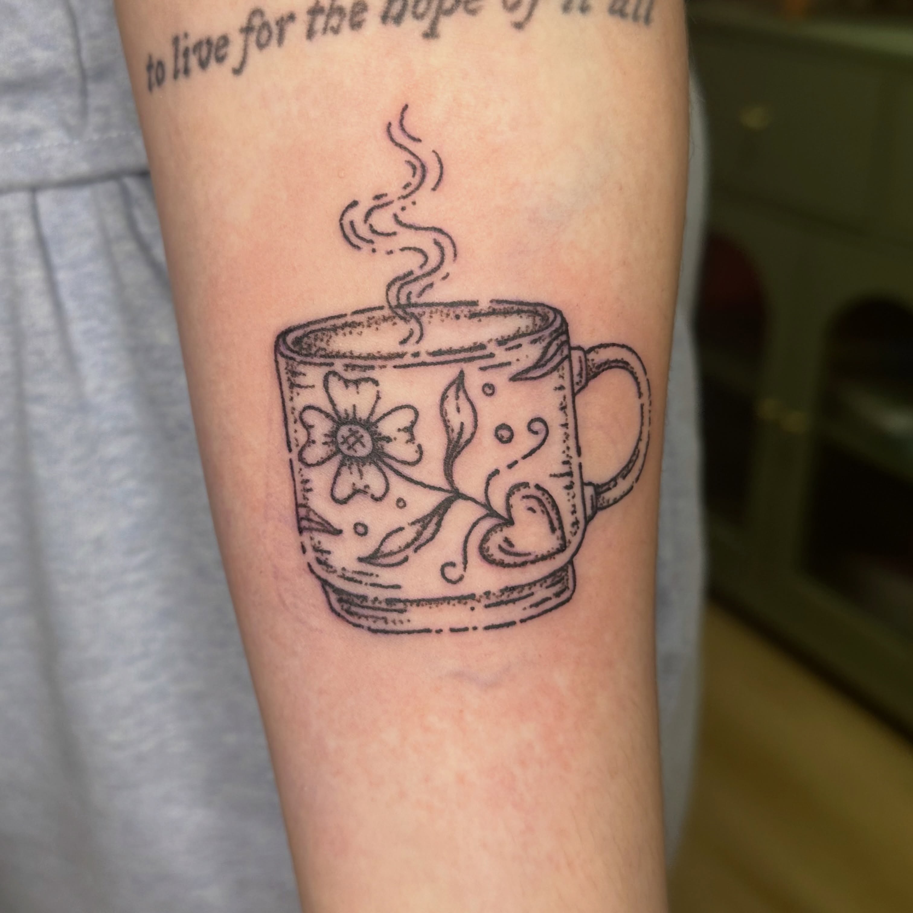 Steaming mug black and grey tattoo on the forearm by Fleur ๐ฅ