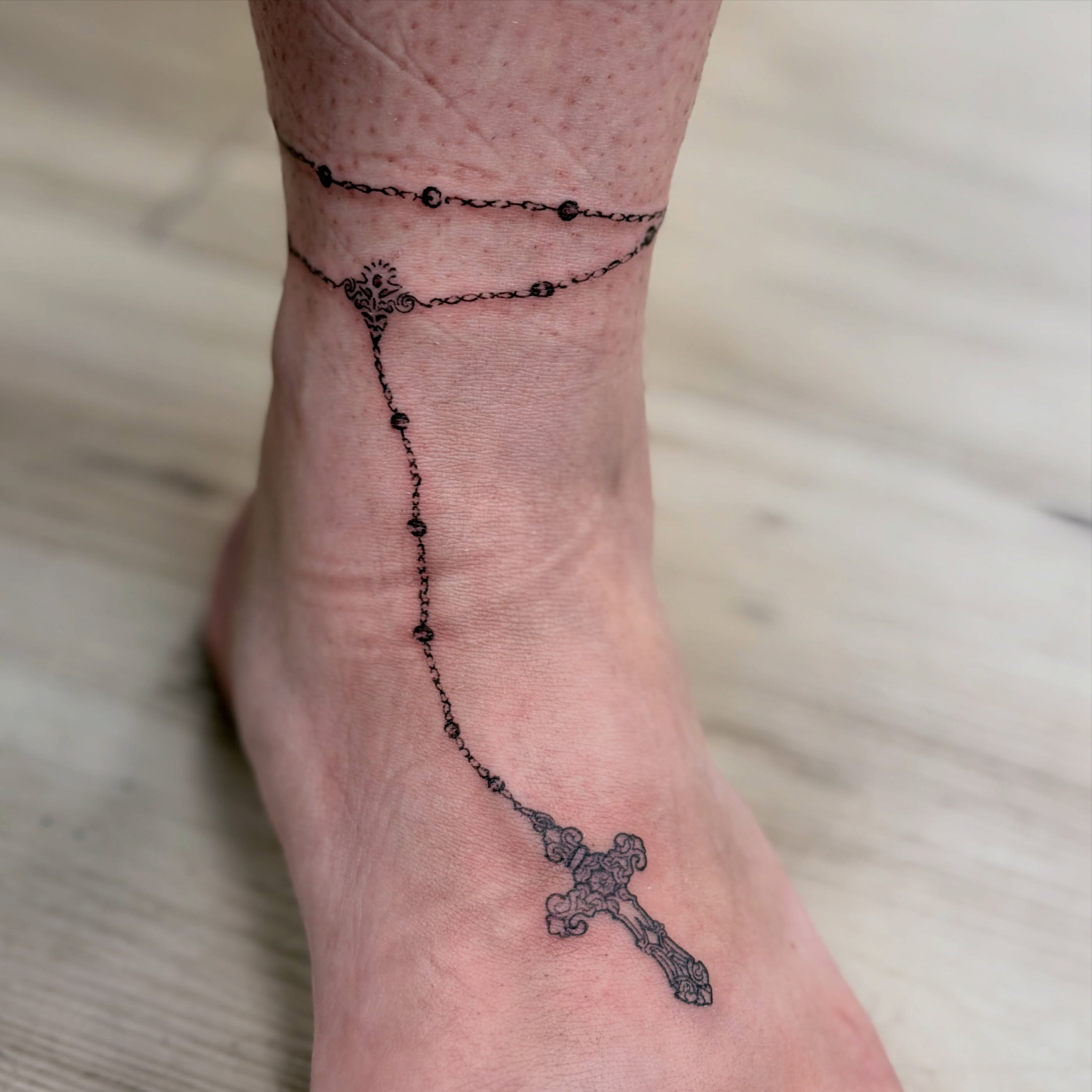 Rosary black and grey tattoo on the foot by Ink About Me - Amanda’s Fine Lines