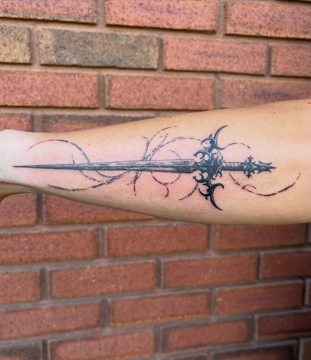 Ornate sword blackwork tattoo on the forearm by Sierra Maynard