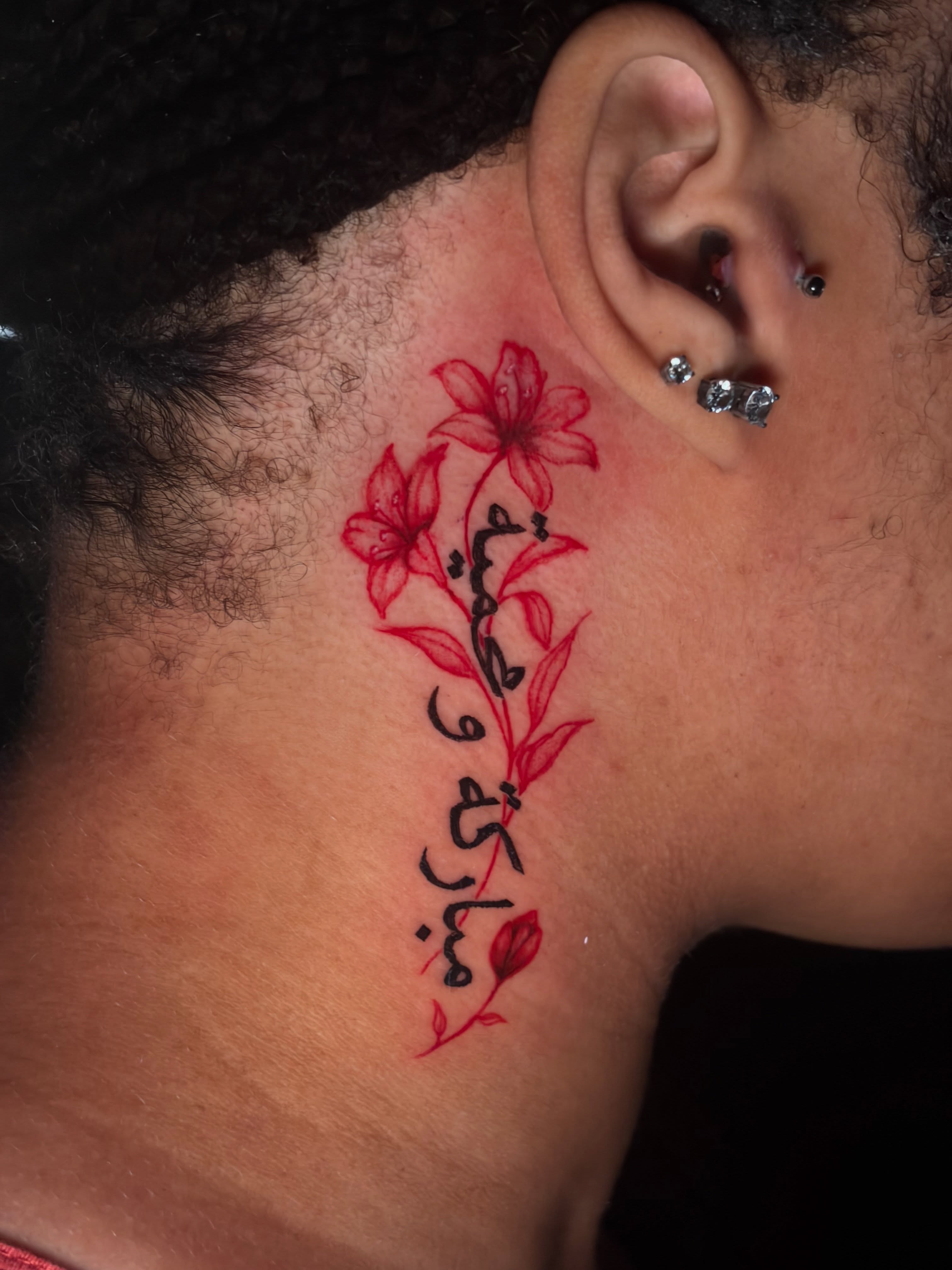 Arabic calligraphy with floral elements lettering script tattoo on the neck by @getmoneetattz