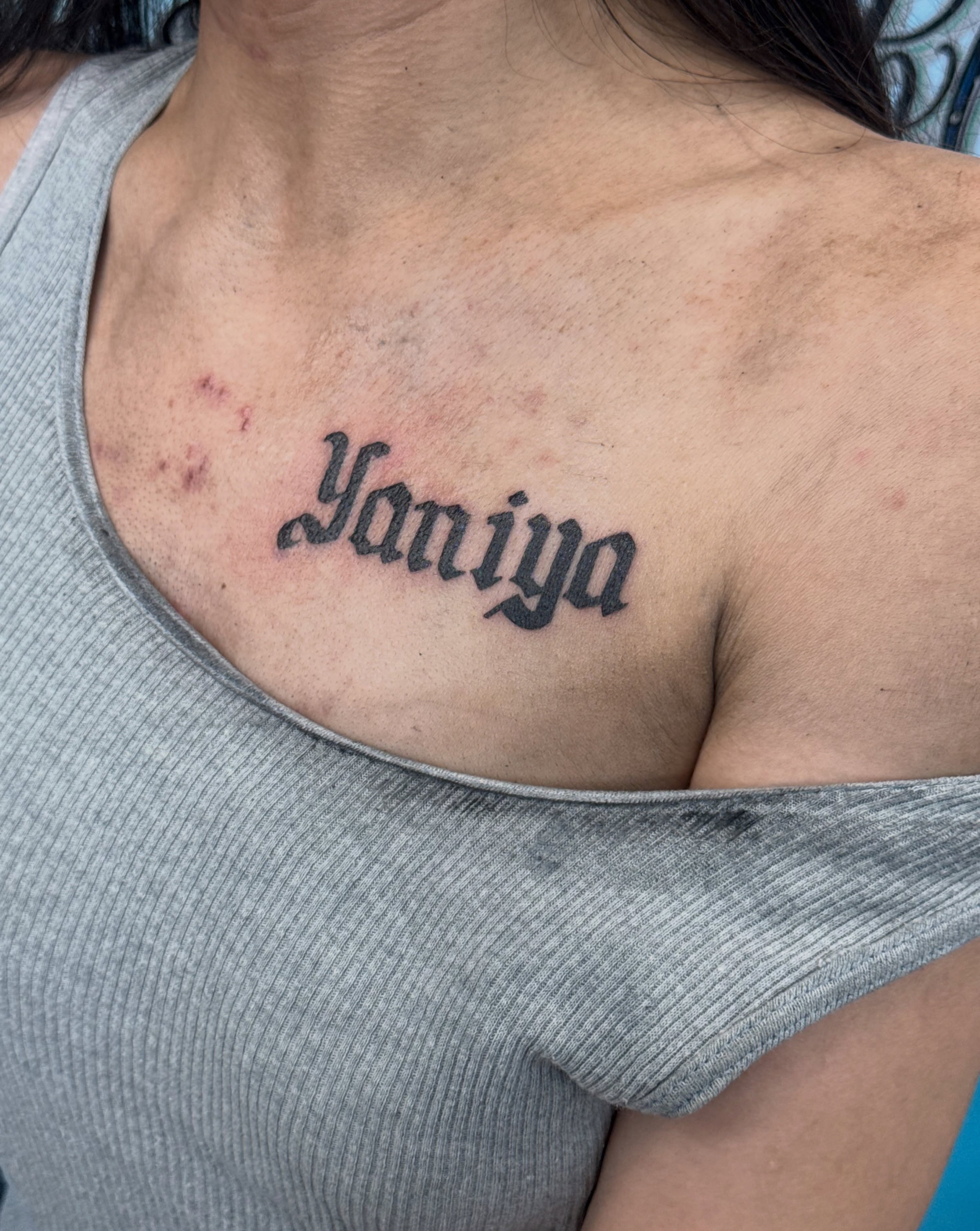 Yaniya lettering script tattoo on the chest by ⠀Greave