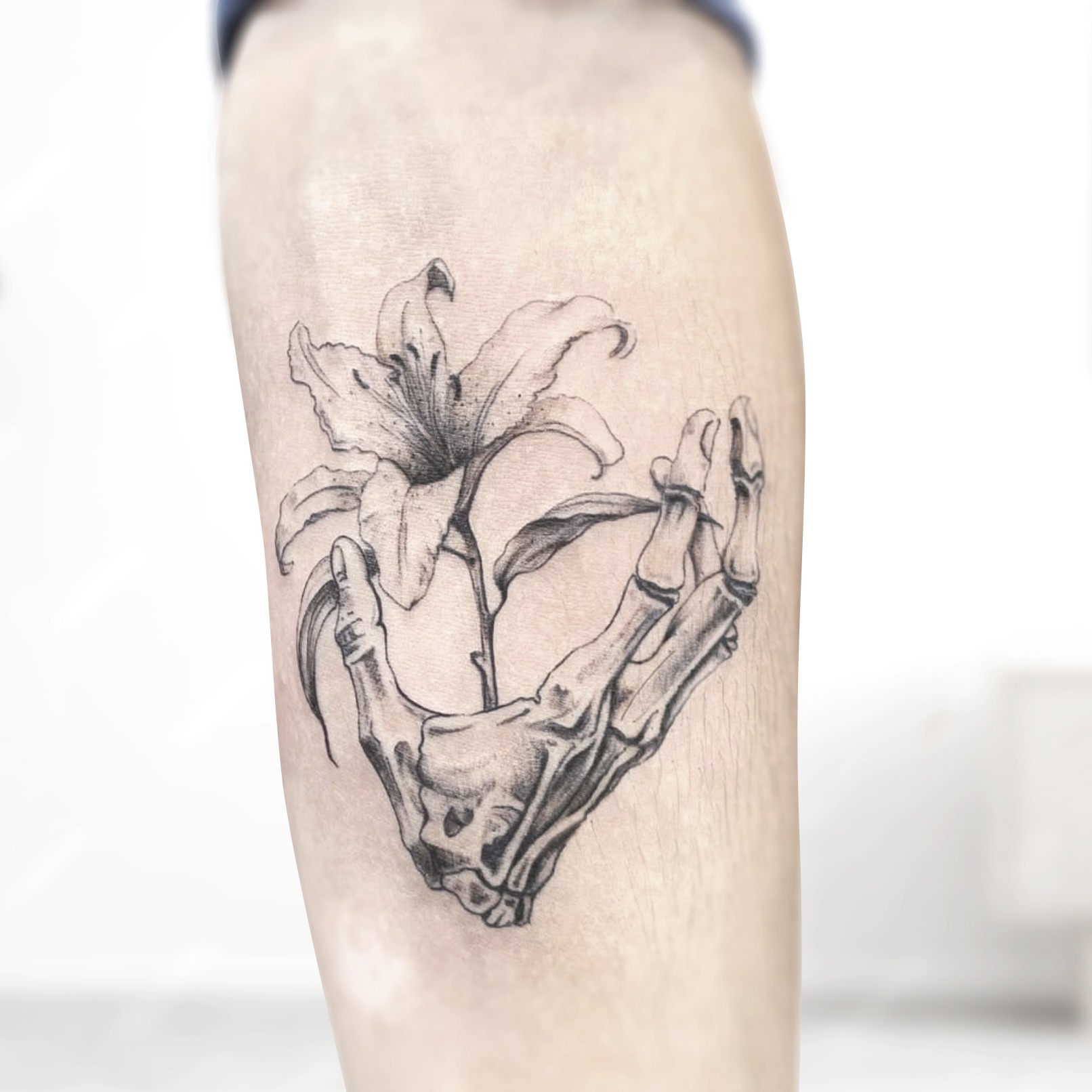 Lily and skeleton hand realism tattoo on the forearm by R o s e