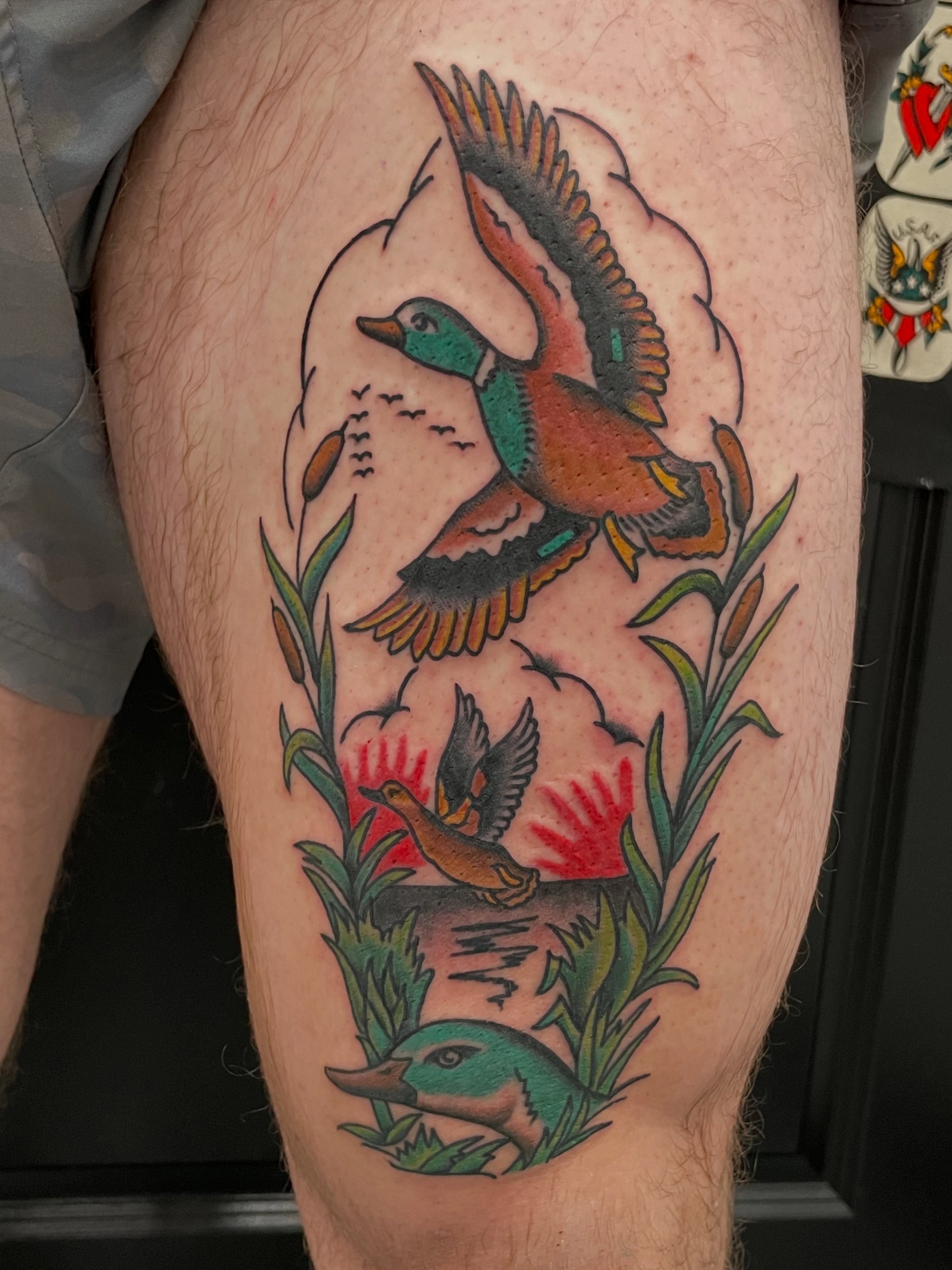 Ducks and cattails American traditional tattoo on the thigh by Greg De Hoot, Youngsville, North Carolina