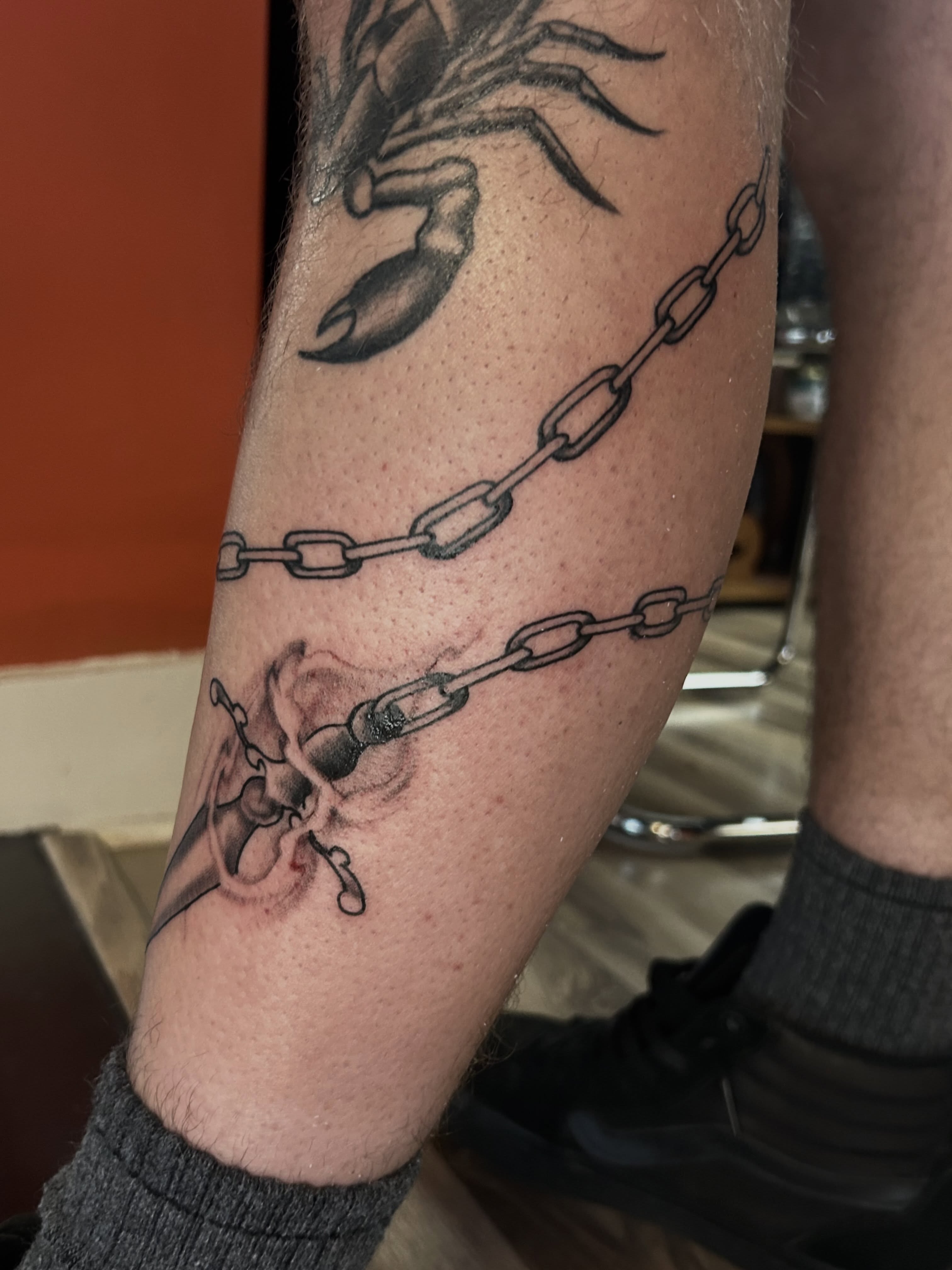 Scorpion and chains black and grey tattoo on the forearm by Dan Schuster