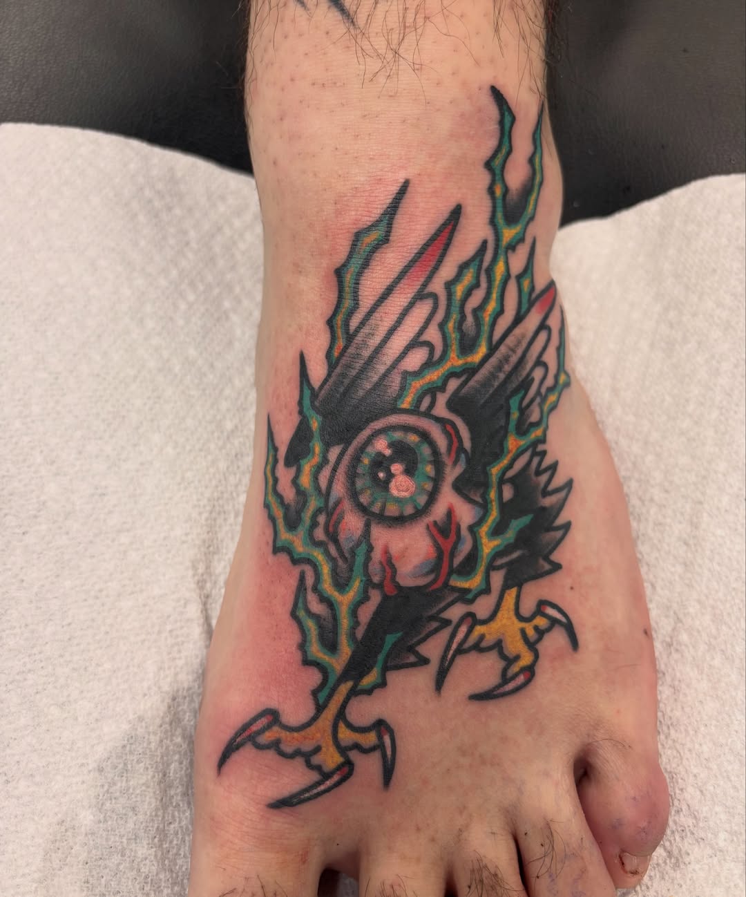 Eye with wings neo-traditional tattoo on the foot by Steve Reid