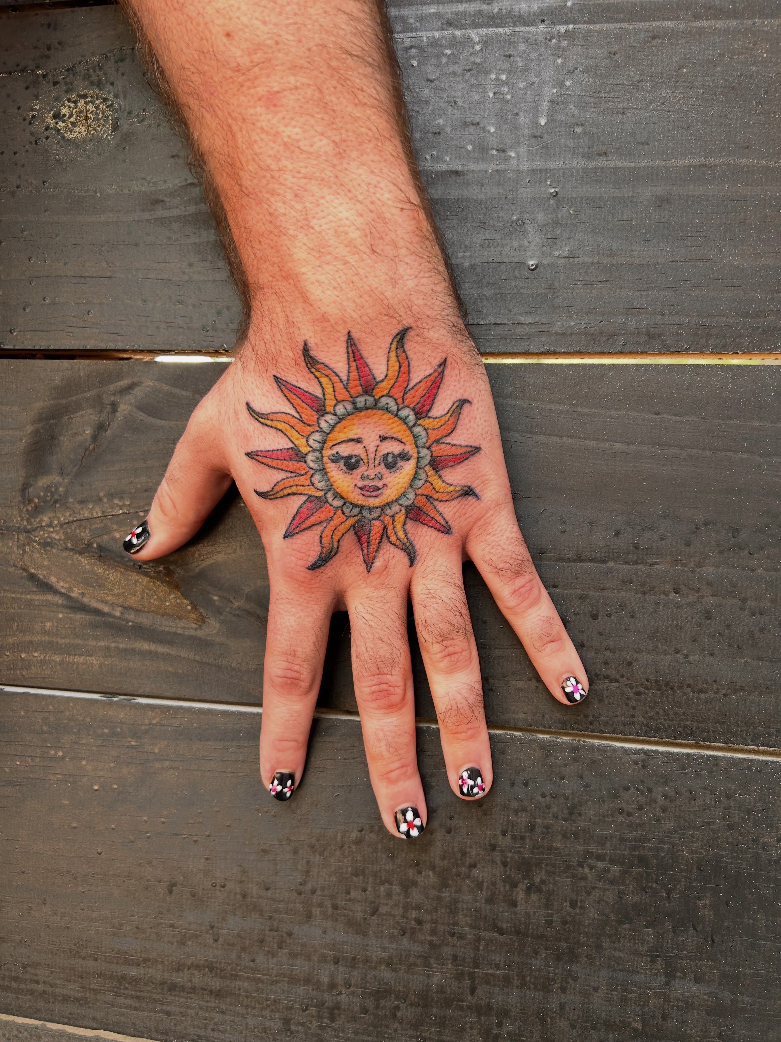 Sun new school tattoo on the hand by Miss Katie