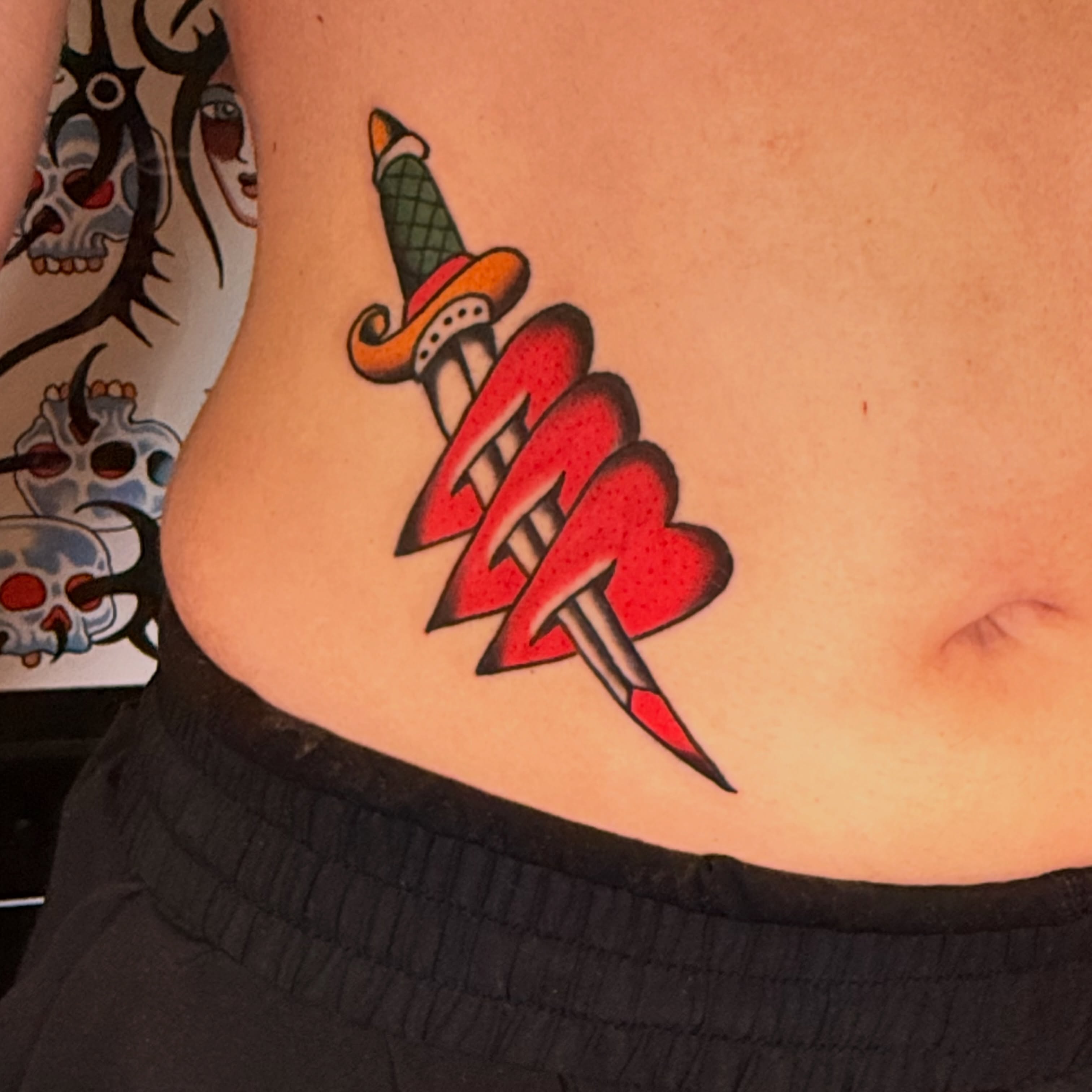 Sword and lightning bolt American traditional tattoo on the torso by {{Theo Glanton}}