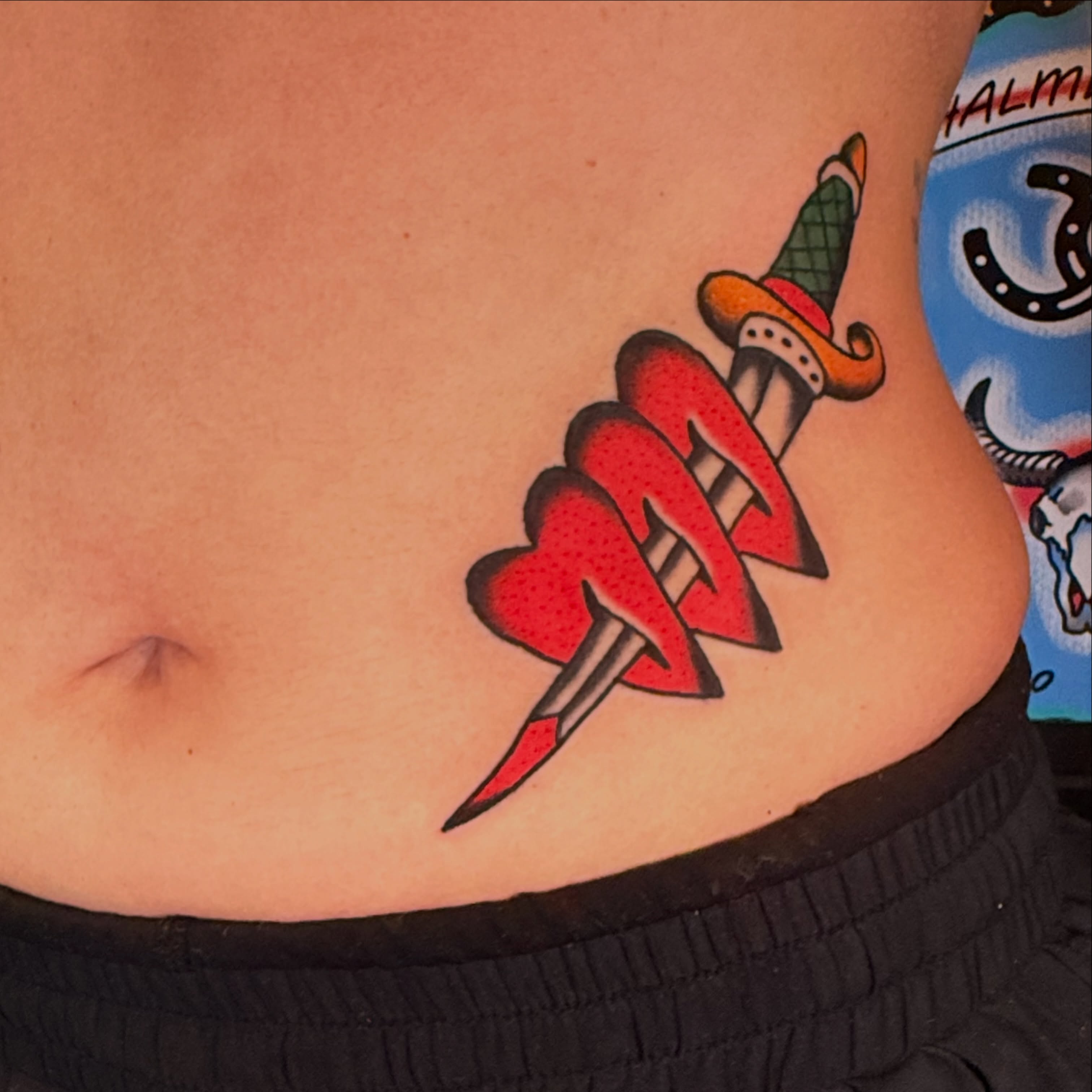 Red lightning bolt American traditional tattoo on the torso by {{Theo Glanton}}