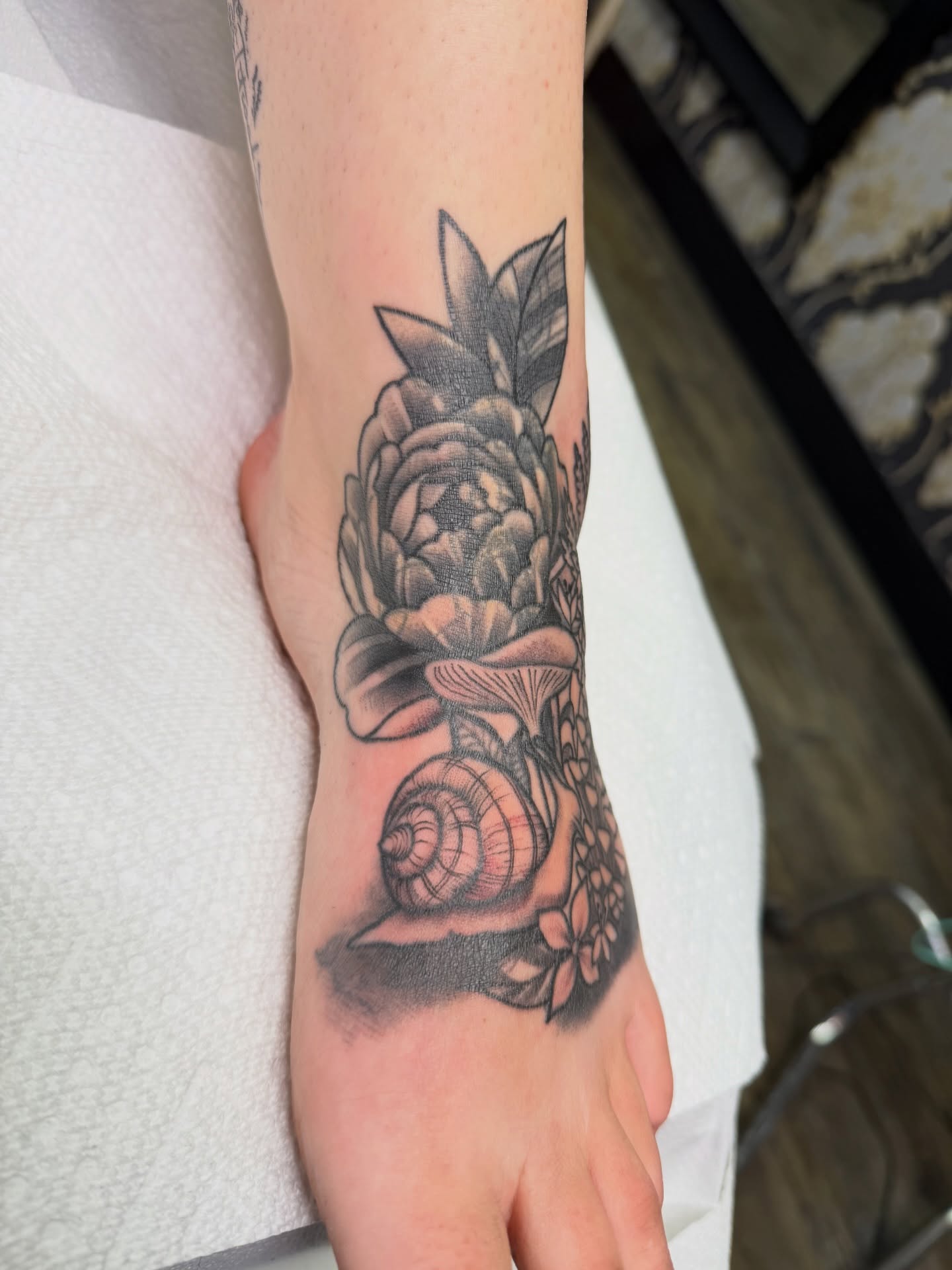Pineapple and seashell realism tattoo on the foot by TyAnne Schulte