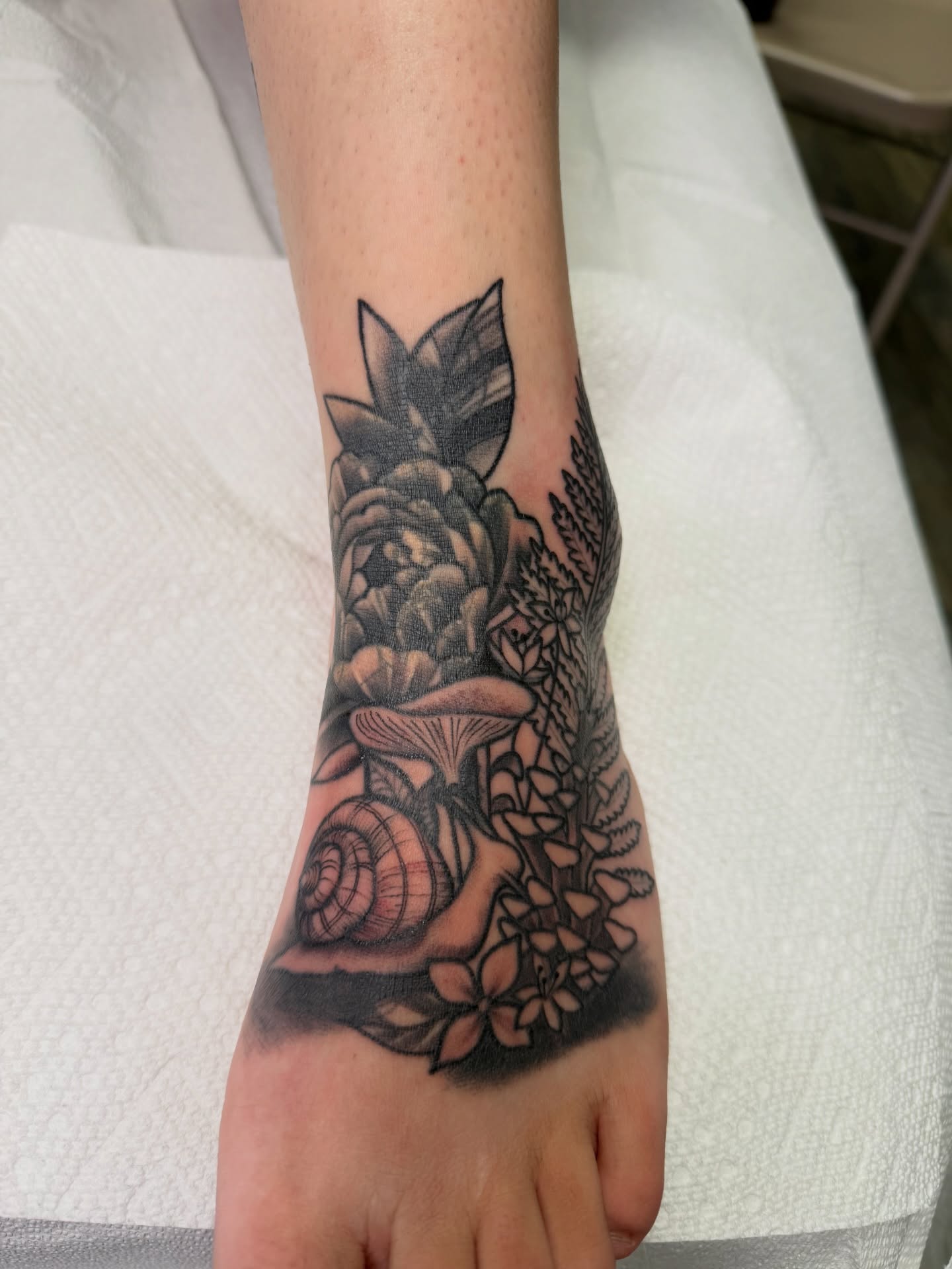 Floral arrangement realism tattoo on the foot by TyAnne Schulte