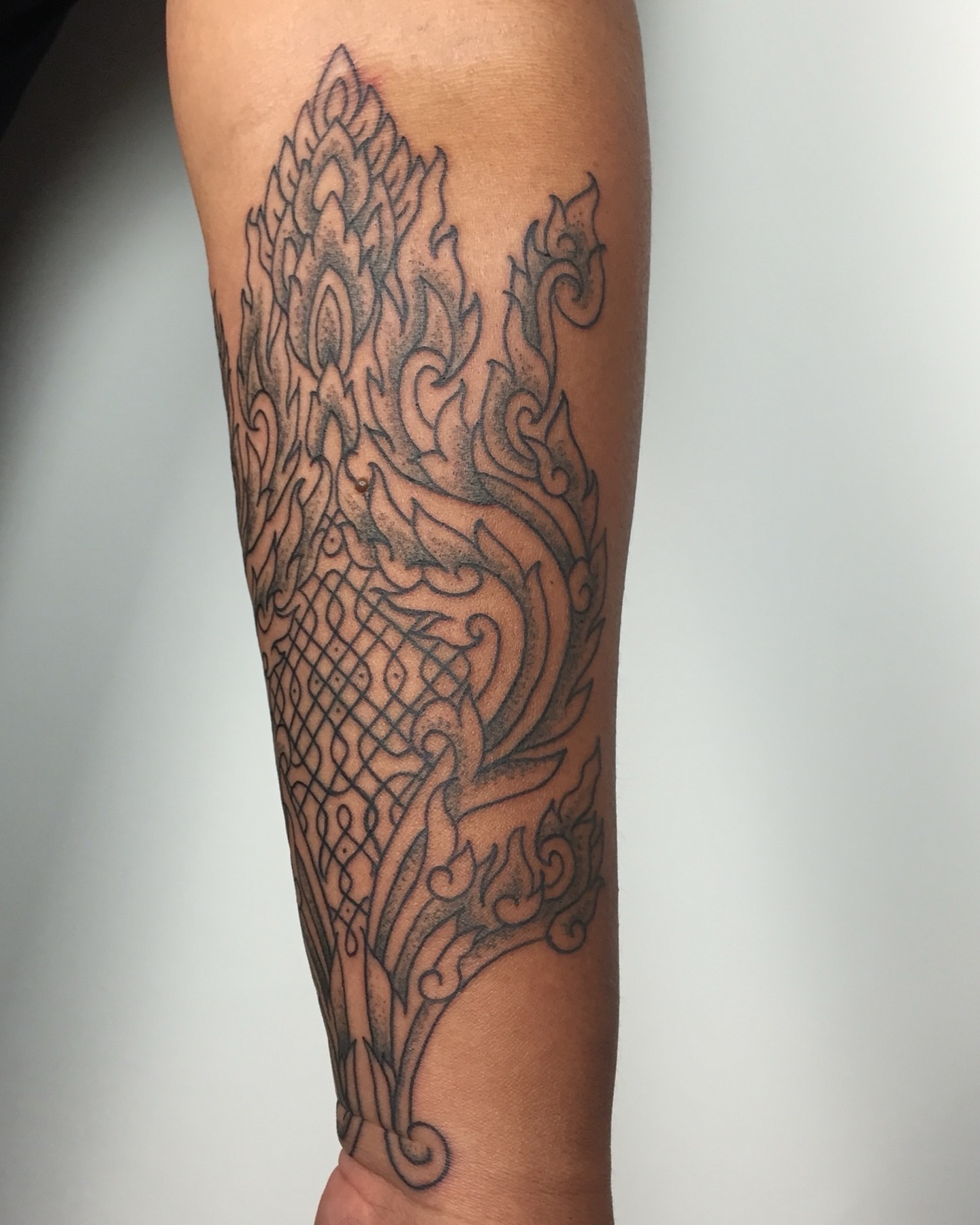 Flame and dragon geometric tattoo on the forearm by Dave Rodriguez