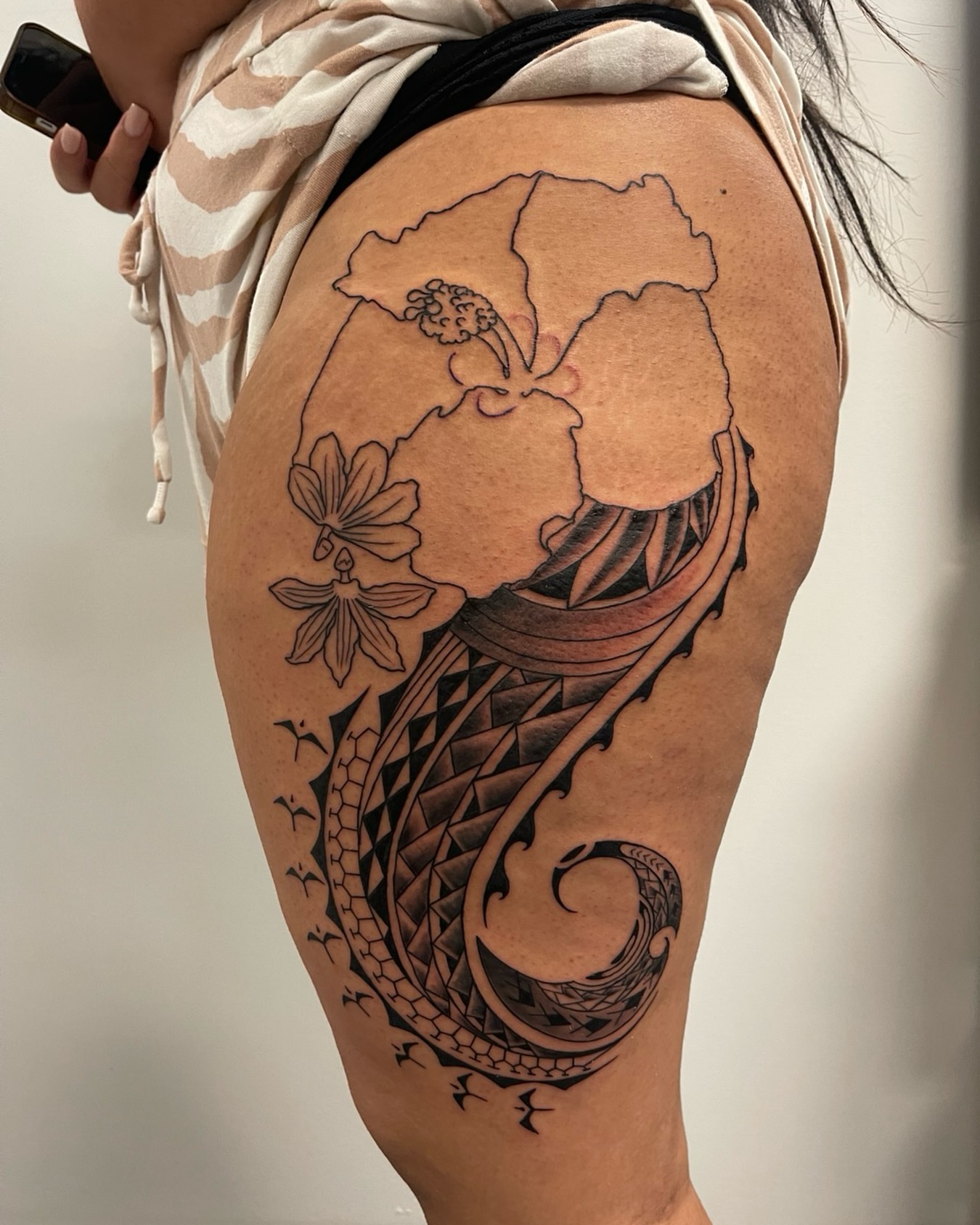 Floral and wave design tribal tattoo on the thigh by Ashley Antolin