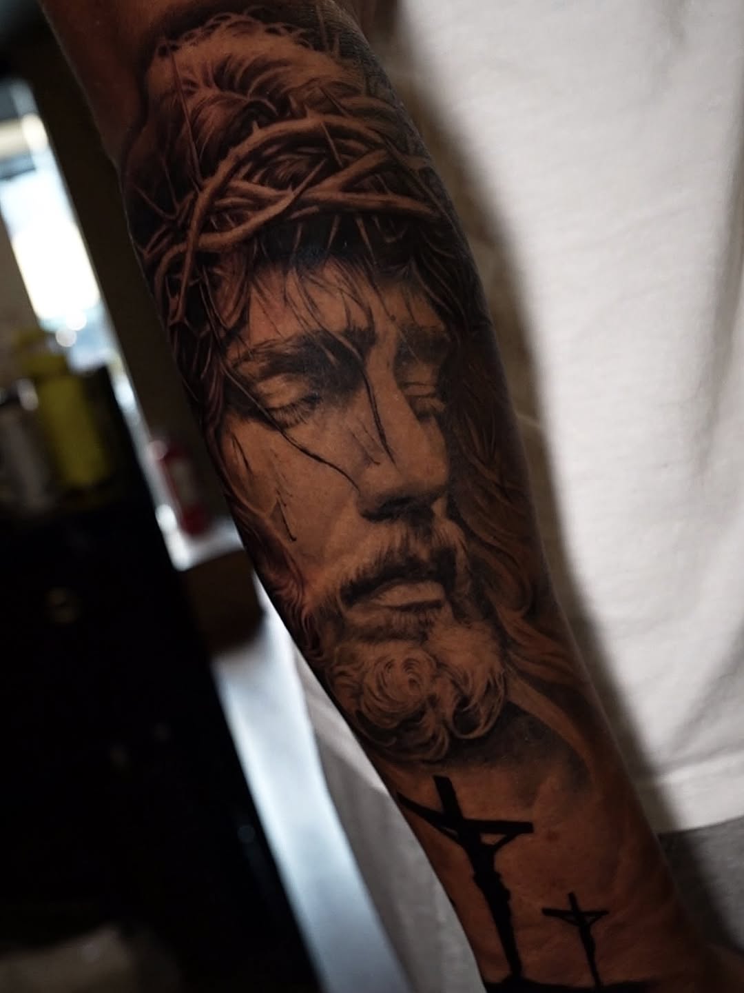 Jesus Christ with crown of thorns realism tattoo on the forearm by Erick Satchell II