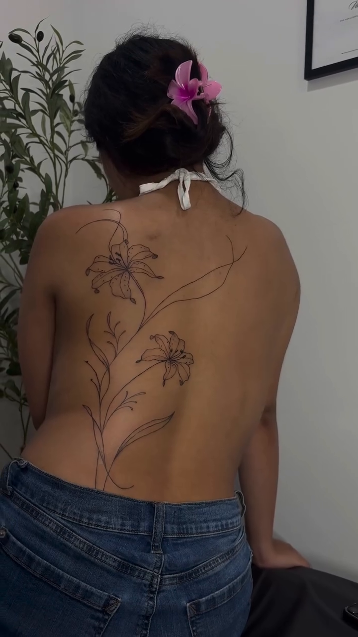 Floral back piece blackwork tattoo on the back by Valentina