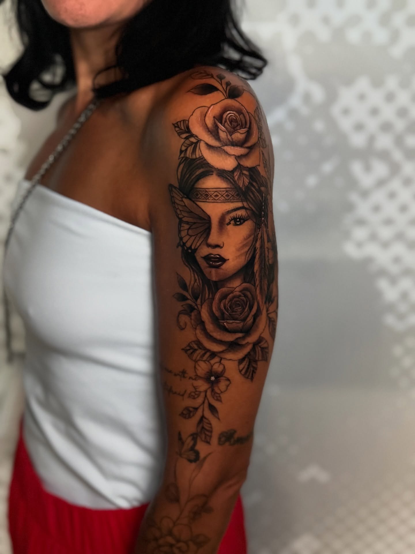Woman with roses realism tattoo on the upper arm by Charlotte Tattoo Artist