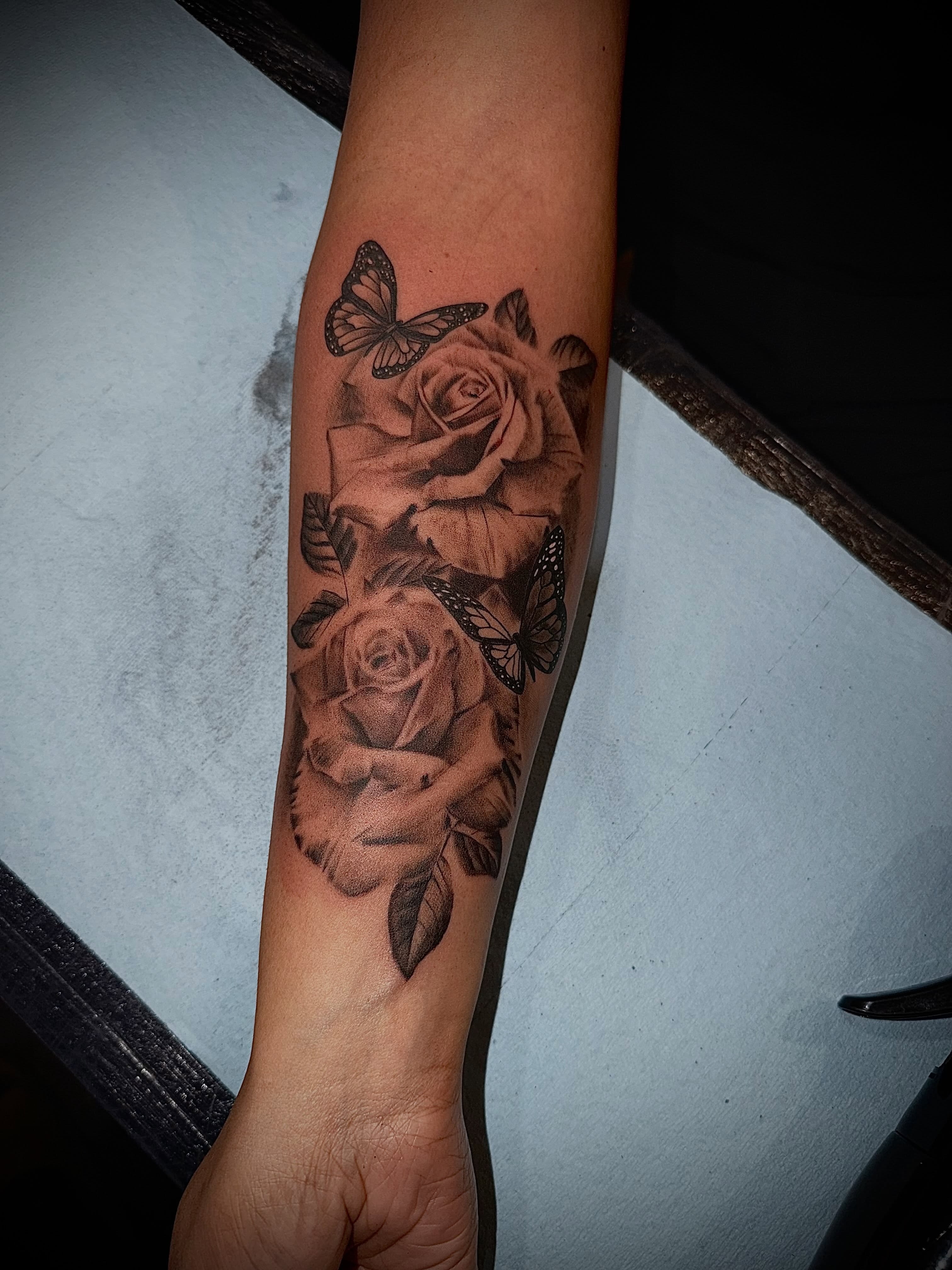 Roses and butterflies realism tattoo on the forearm by Clifford Jordan