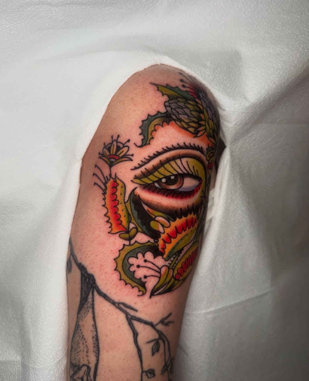 Eye and floral American traditional tattoo on the forearm by Lexie Graff
