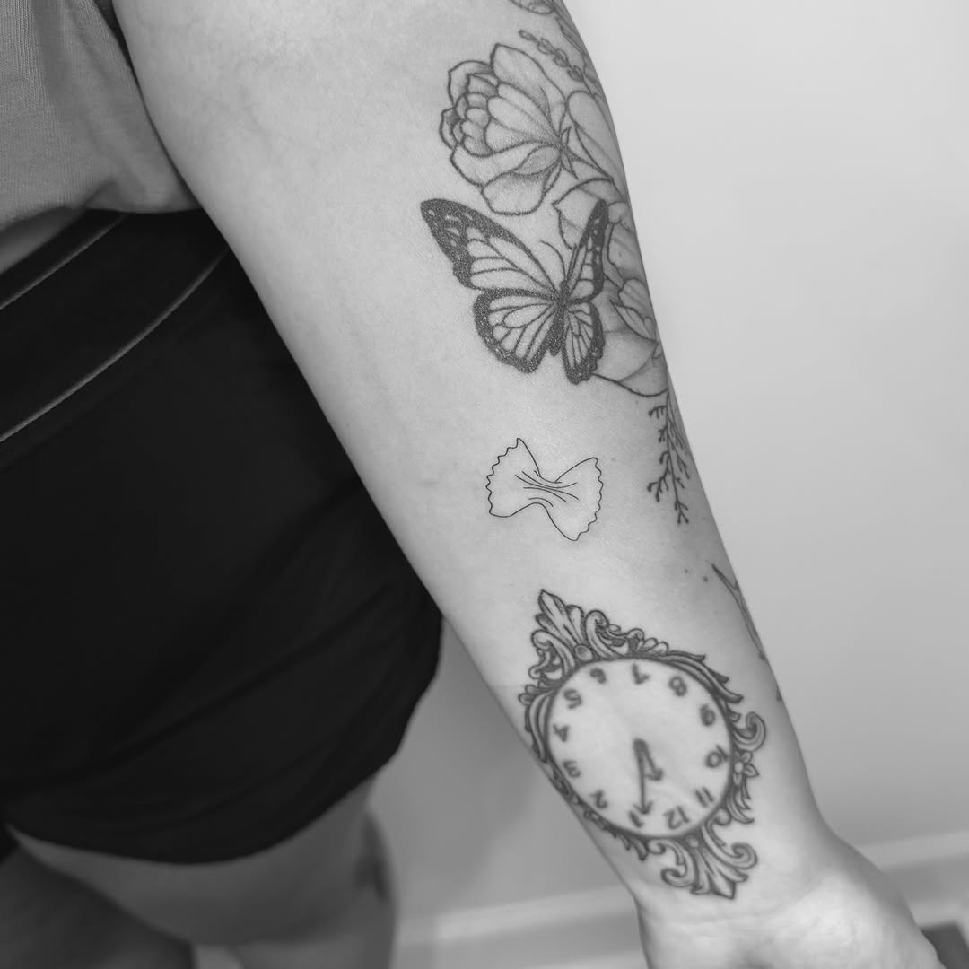 Butterfly, flower, clock, pasta black and grey tattoo on the forearm by Jessica, Cheektowaga, New York