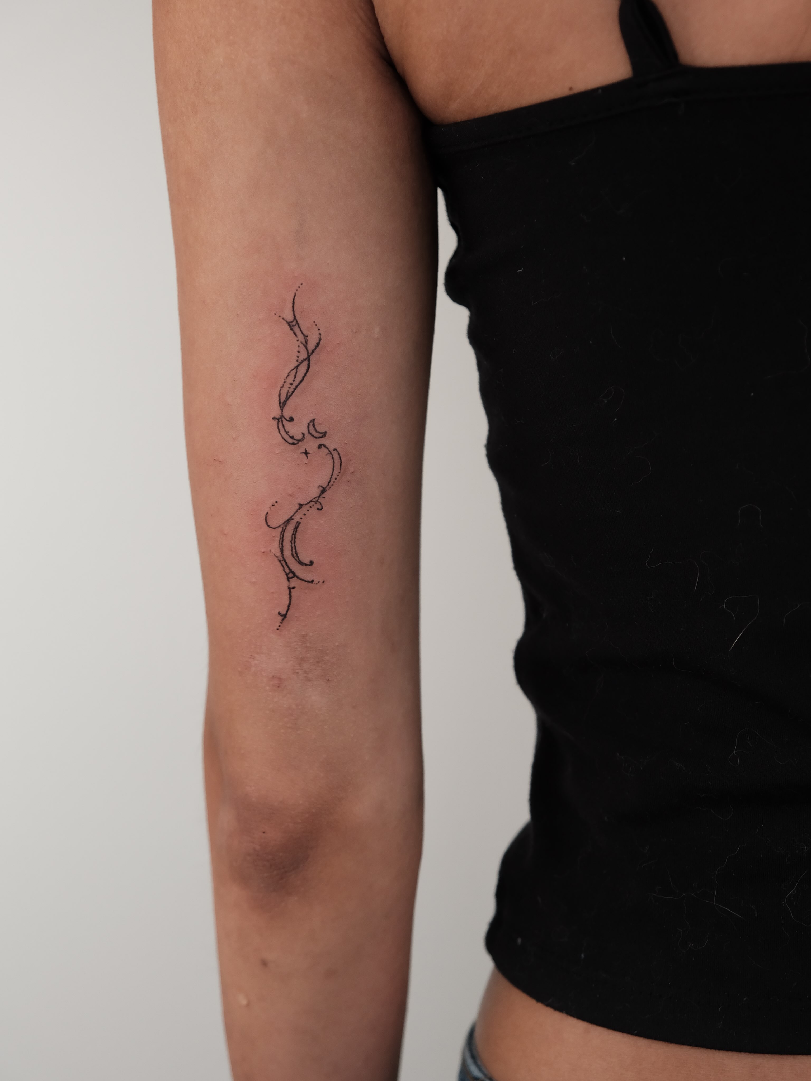Abstract swirls fine line tattoo on the forearm by Elana Hites