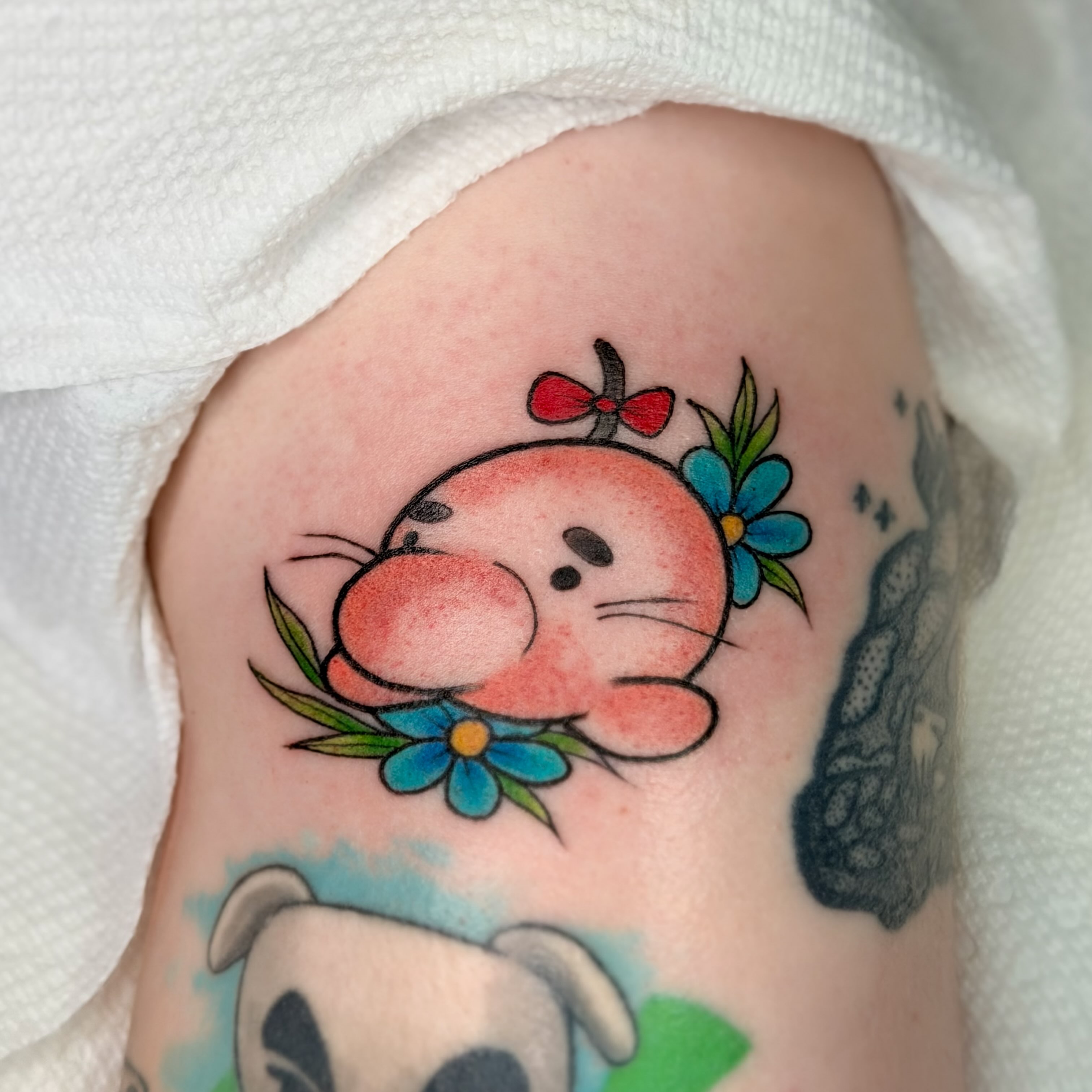 Pink cat with flowers new school tattoo on the forearm by Constance Roberts