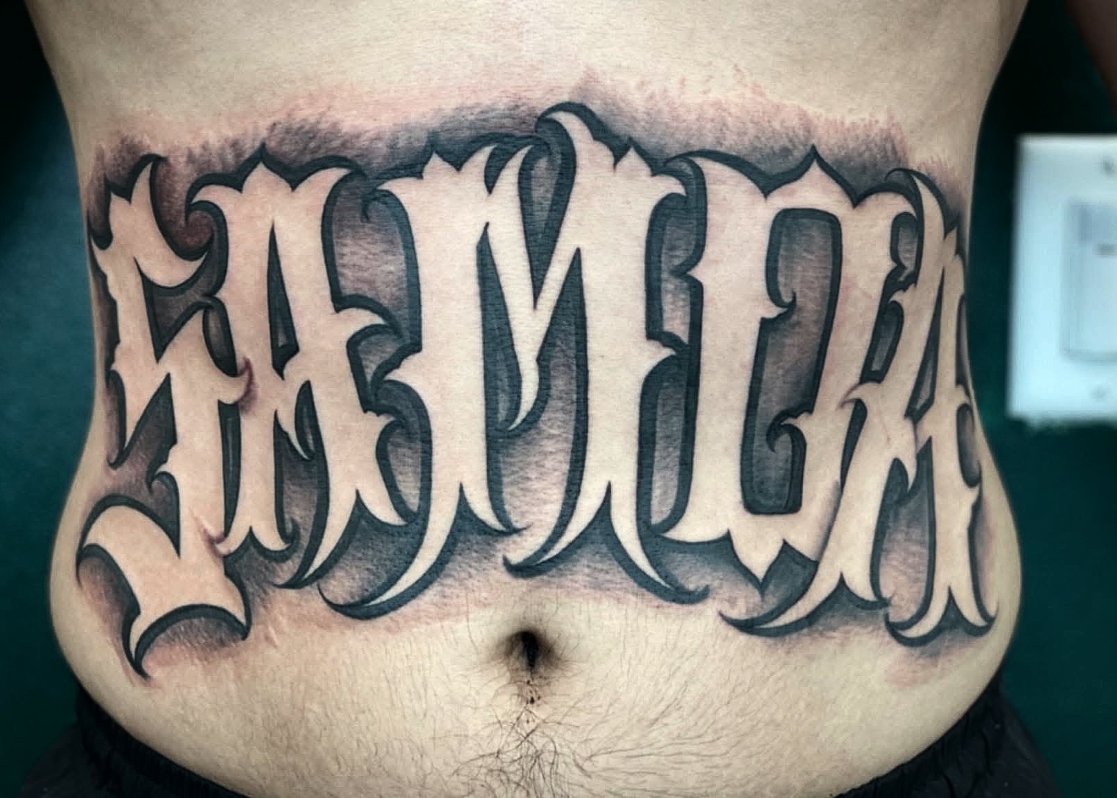 Jamaica lettering script tattoo on the torso by Lex Miranda