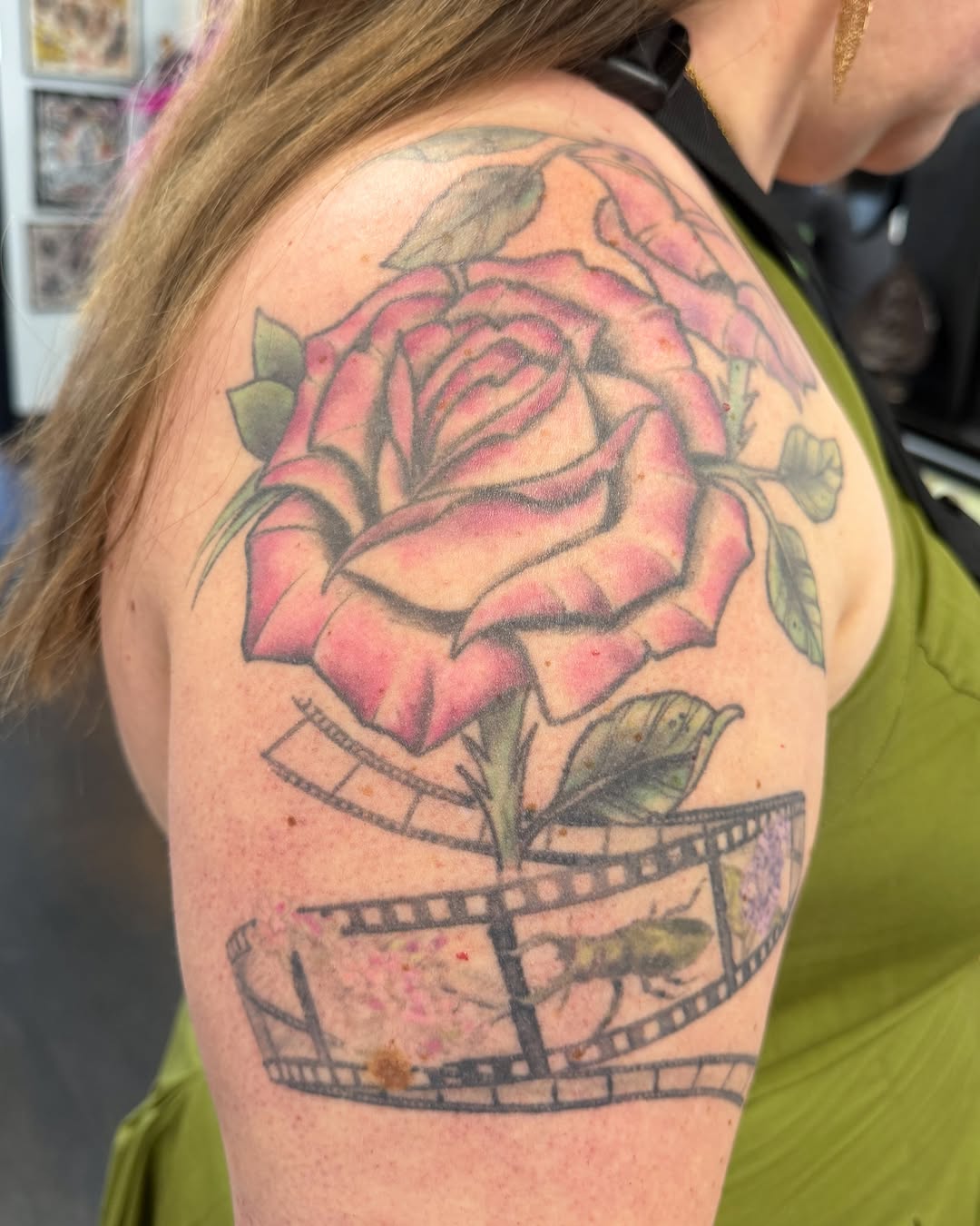 Rose and filmstrip realism tattoo on the shoulder by Zac Tattooer