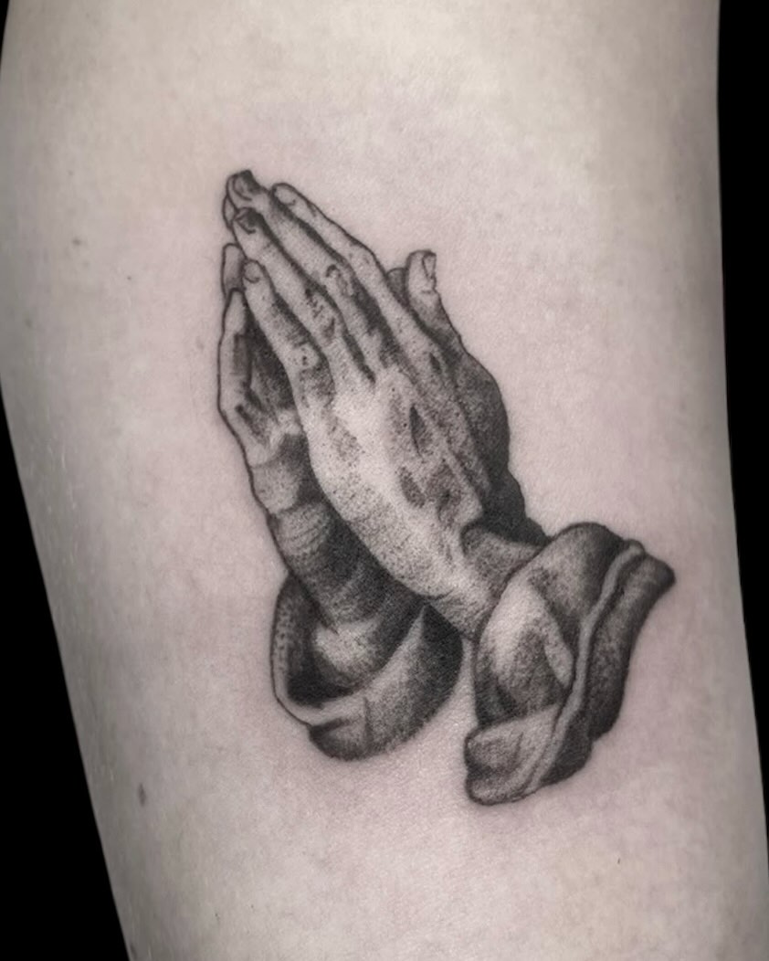Praying hands dotwork tattoo on the forearm by Cody Glenn