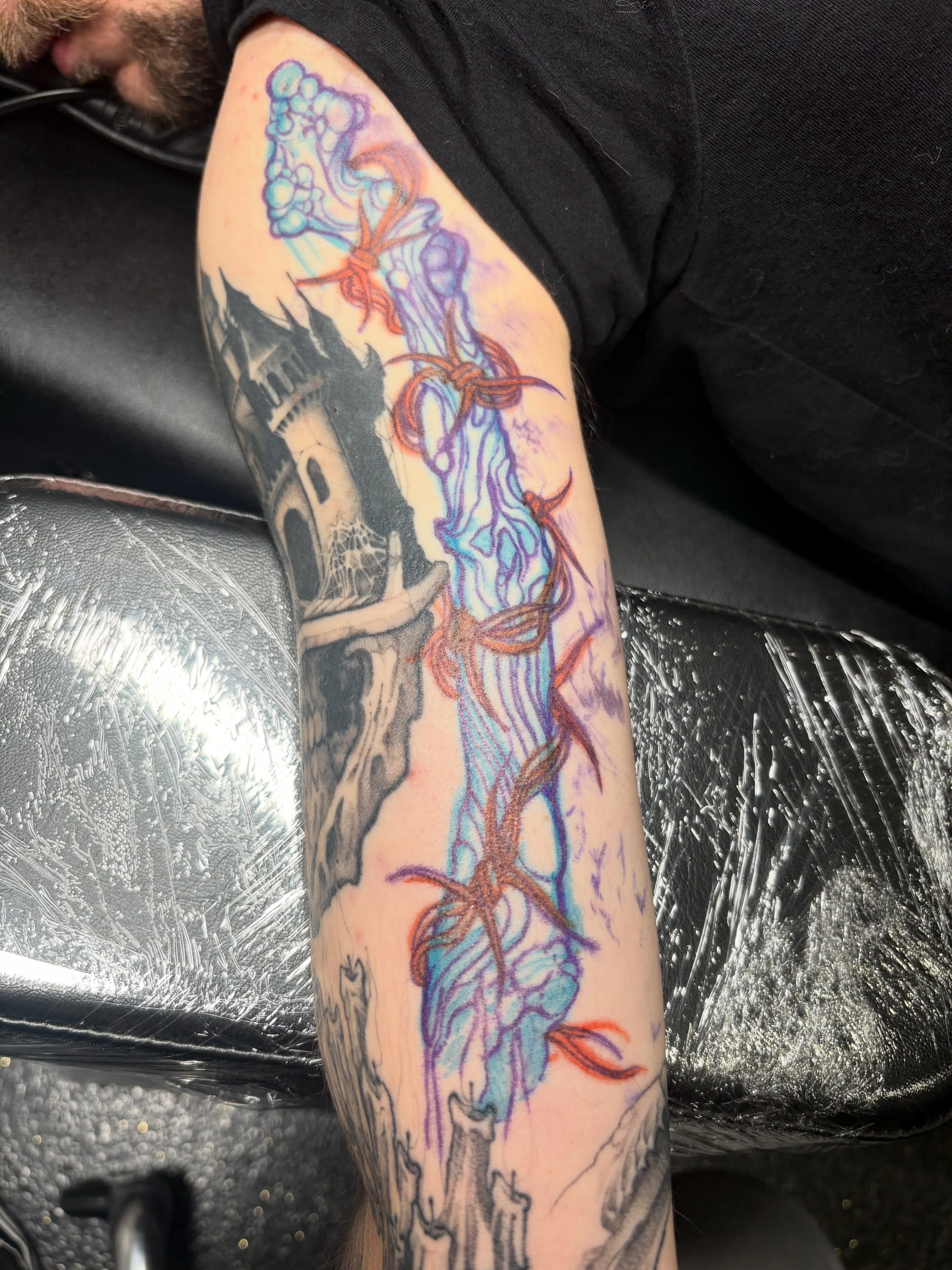Castle and ghostly figure new school tattoo on the forearm by Eddie Wolfe
