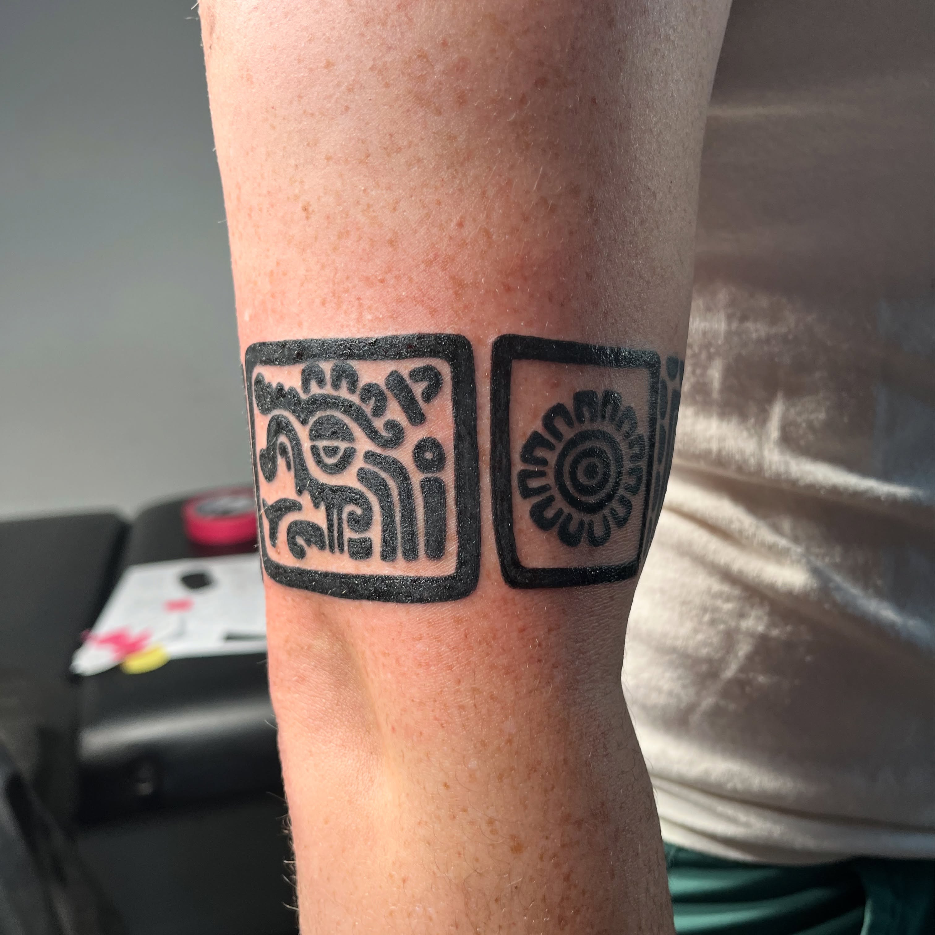 Ancient symbols black and grey tattoo on the forearm by christina diaz