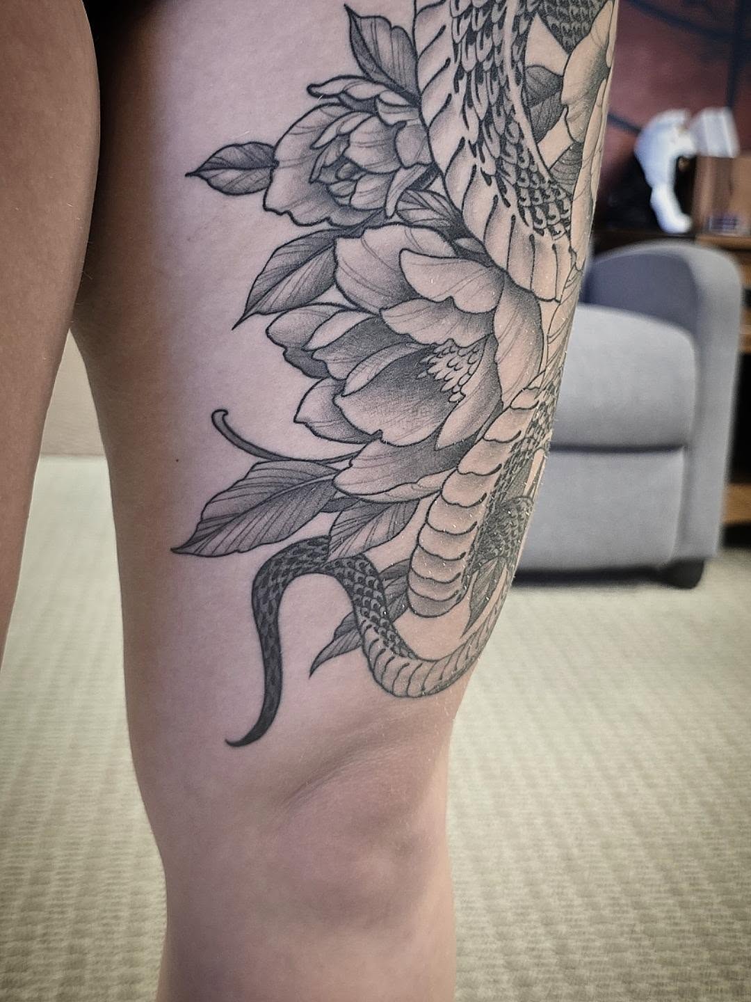 Snake and peony realism tattoo on the thigh by Alexander L. Wolff, Rapid City, South Dakota