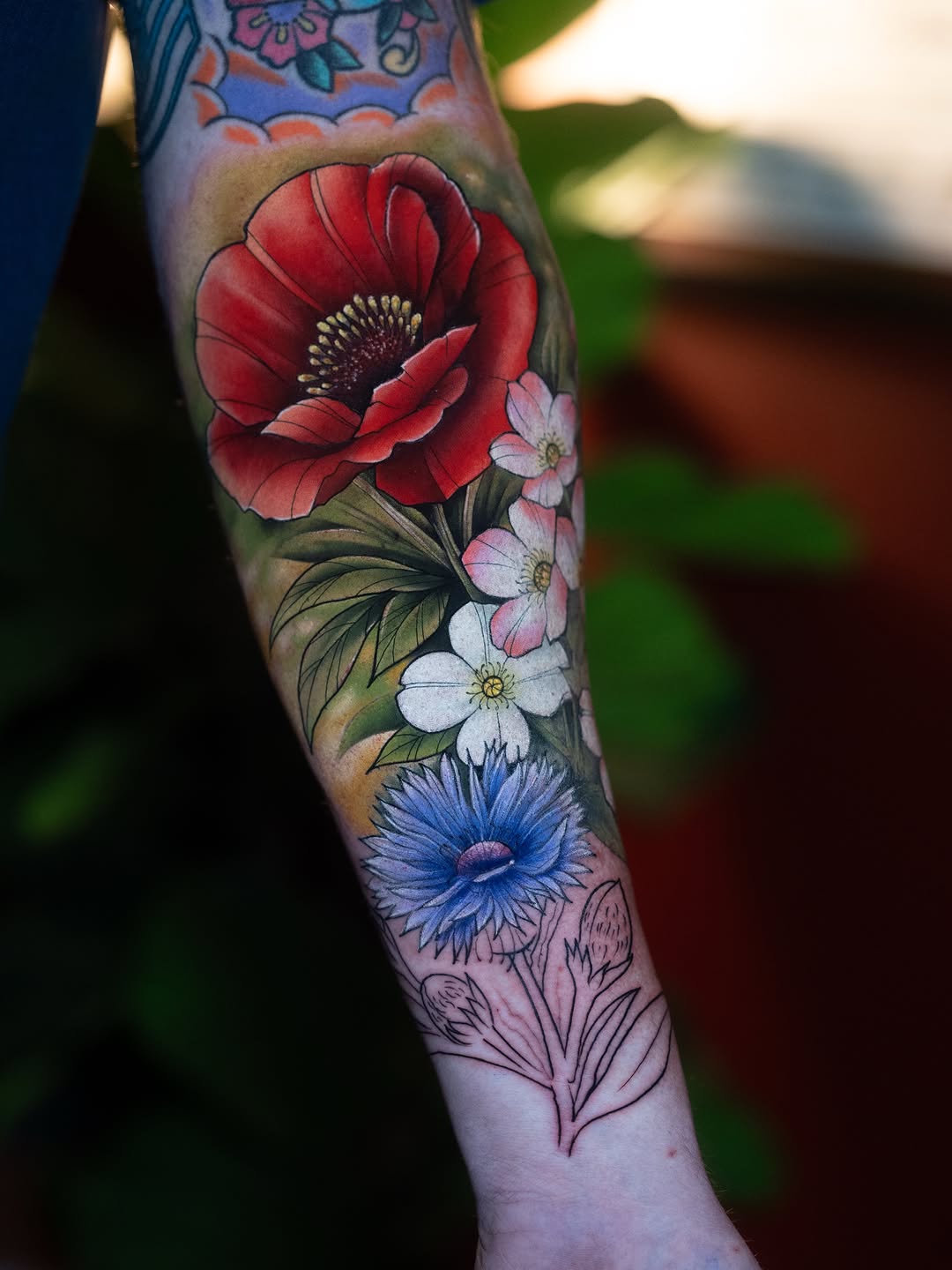 Poppy and cornflower bouquet neo-traditional tattoo on the forearm by Franz Muñoz