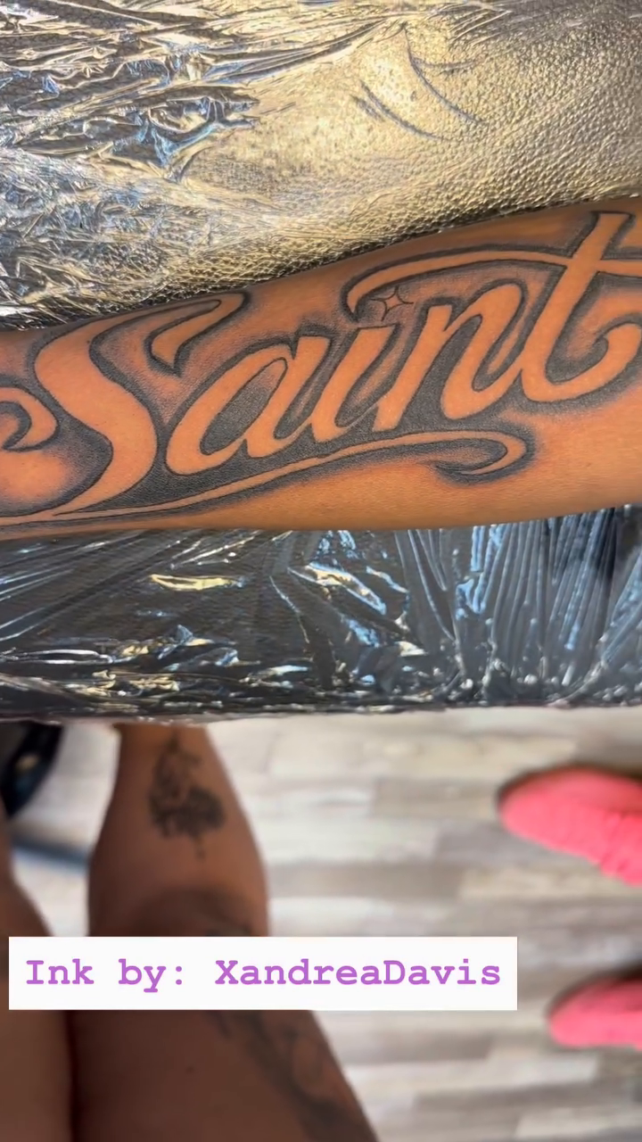 Saint lettering lettering tattoo on the upper arm by XoXandrea.Ink, Kansas City, Missouri
