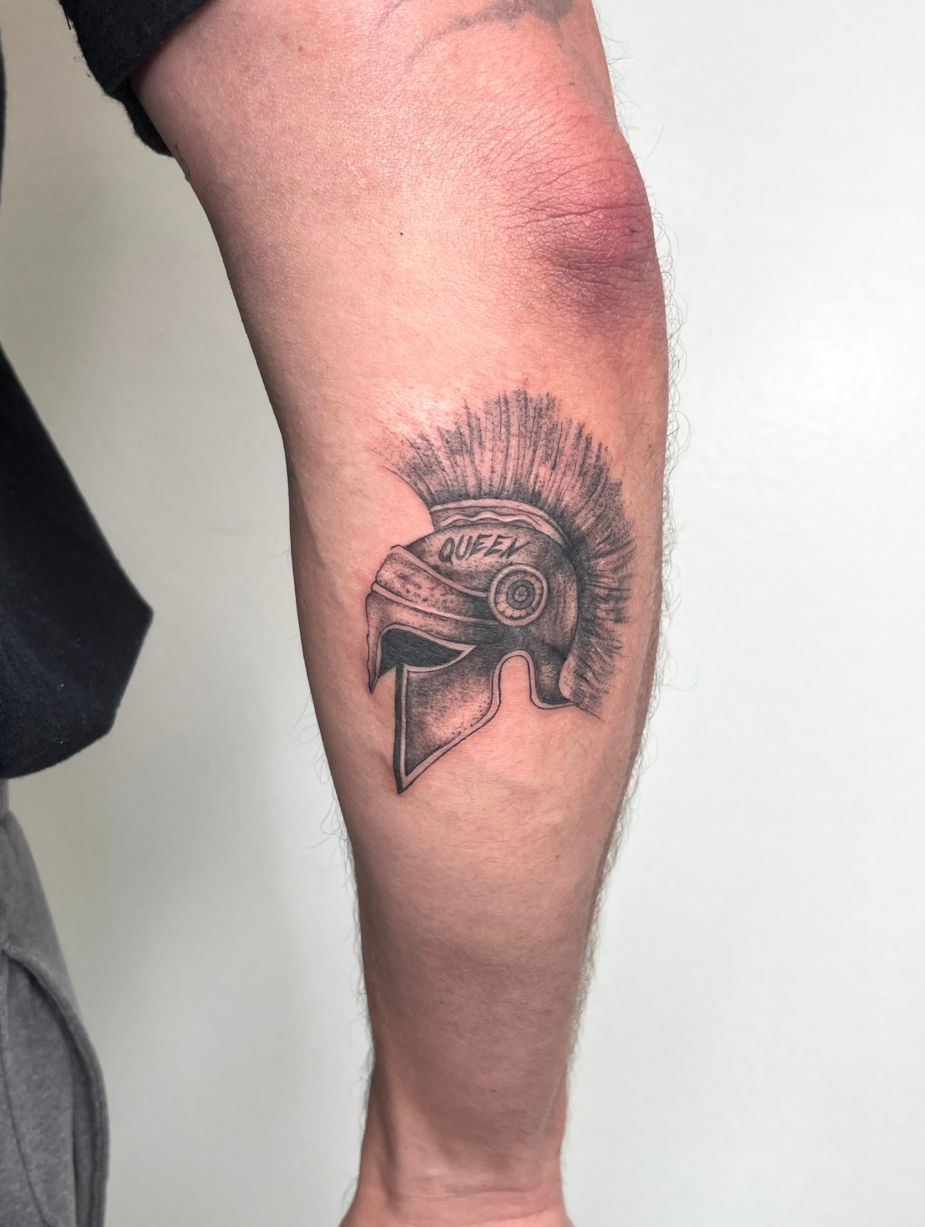 Spartan helmet black and grey tattoo on the forearm by kt