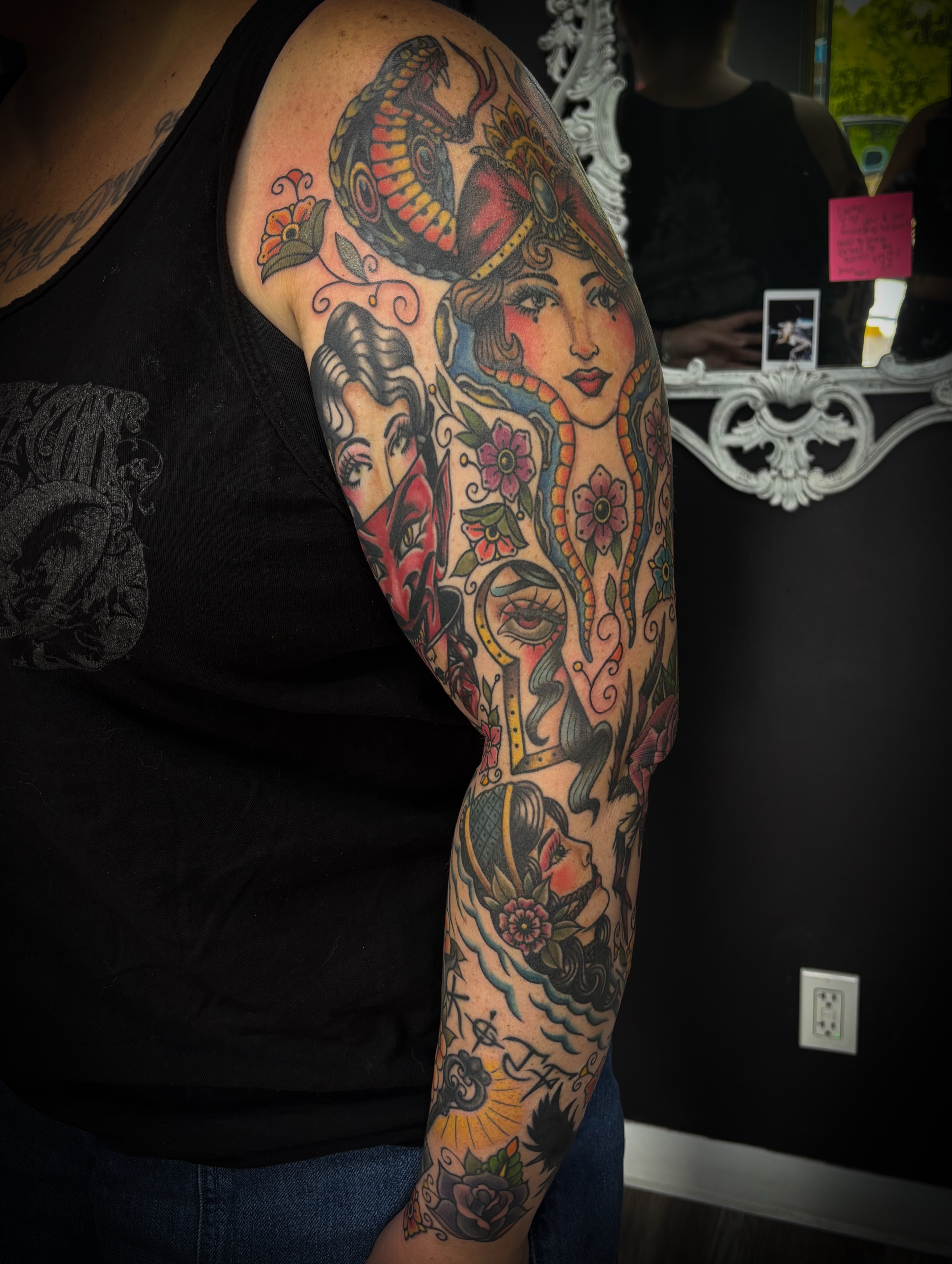 Woman with snake American traditional tattoo on the upper arm by Shiann Null