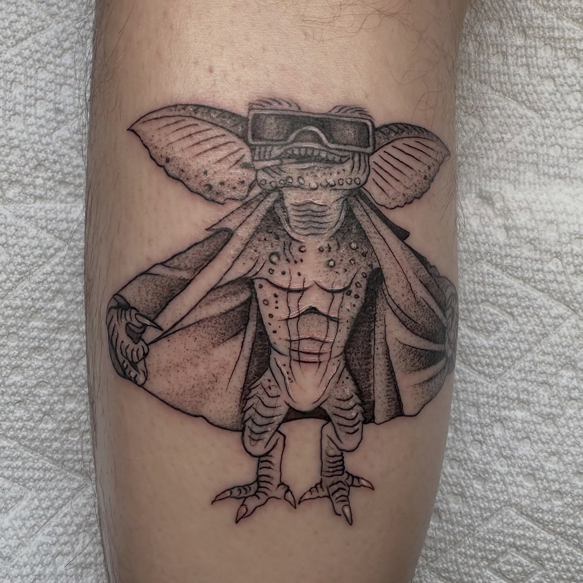 Gremlin wearing goggles dotwork tattoo on the forearm by Lia Massari