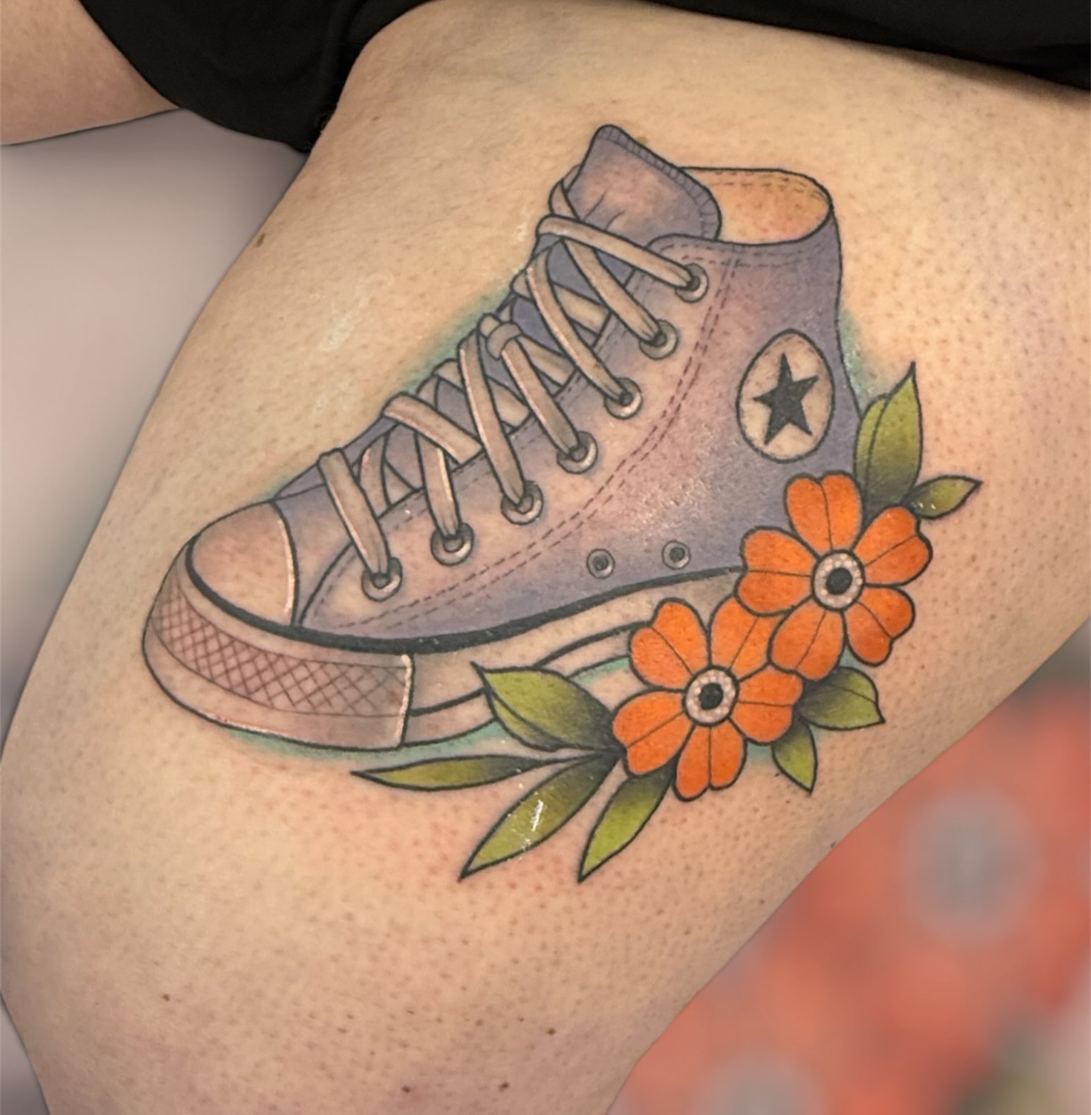 High-top sneaker with flowers American traditional tattoo on the thigh by Dameetra Davis