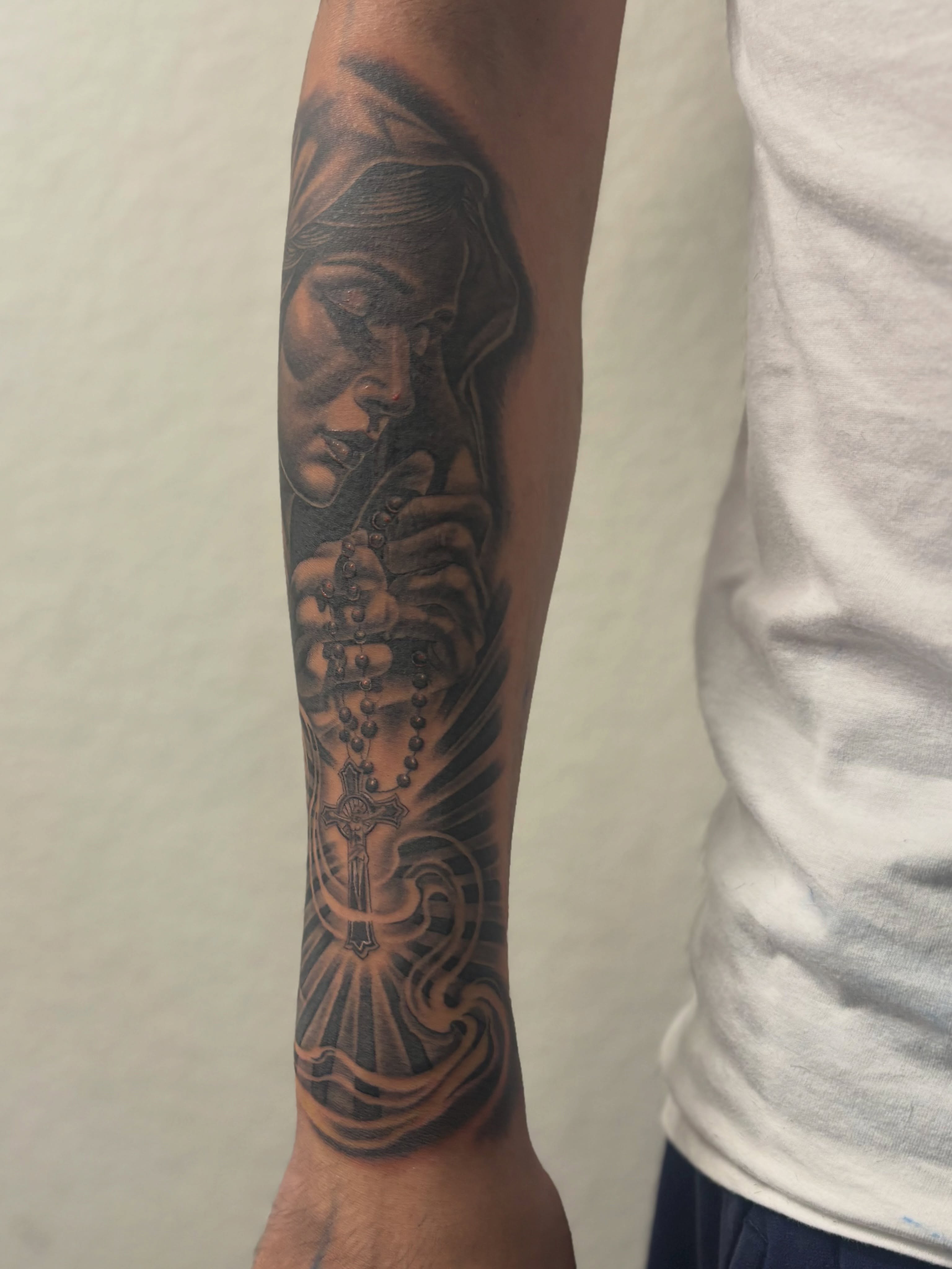 Praying woman with rosary realism tattoo on the forearm by @tattoosbyadrian