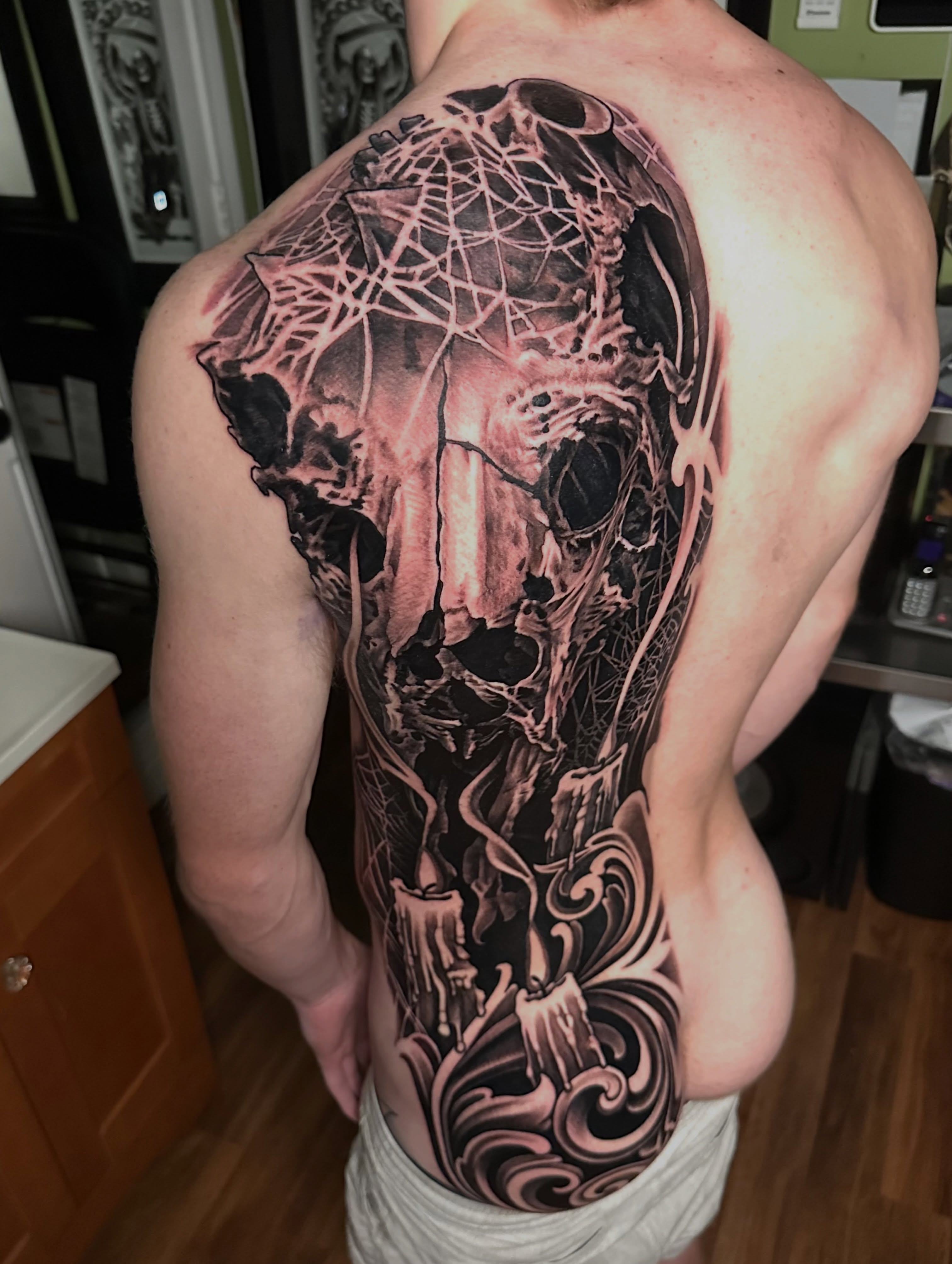 Skull and spiderweb dark realism tattoo on the back by Trevor Burtz