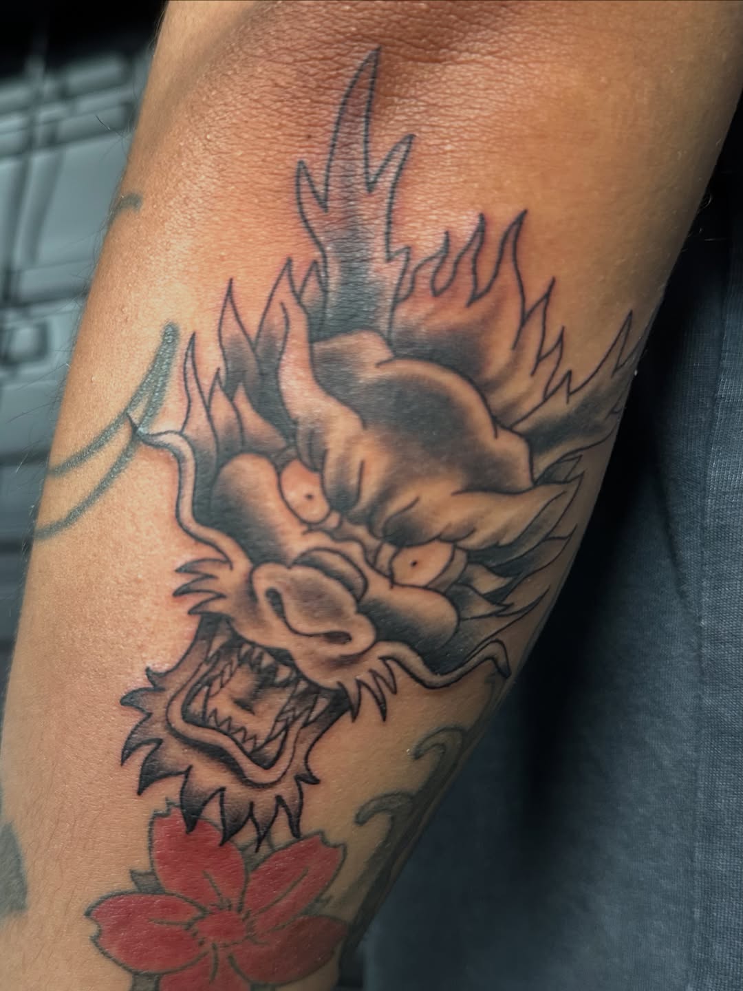 Dragon head and flower Japanese tattoo on the forearm by Alexander Haber