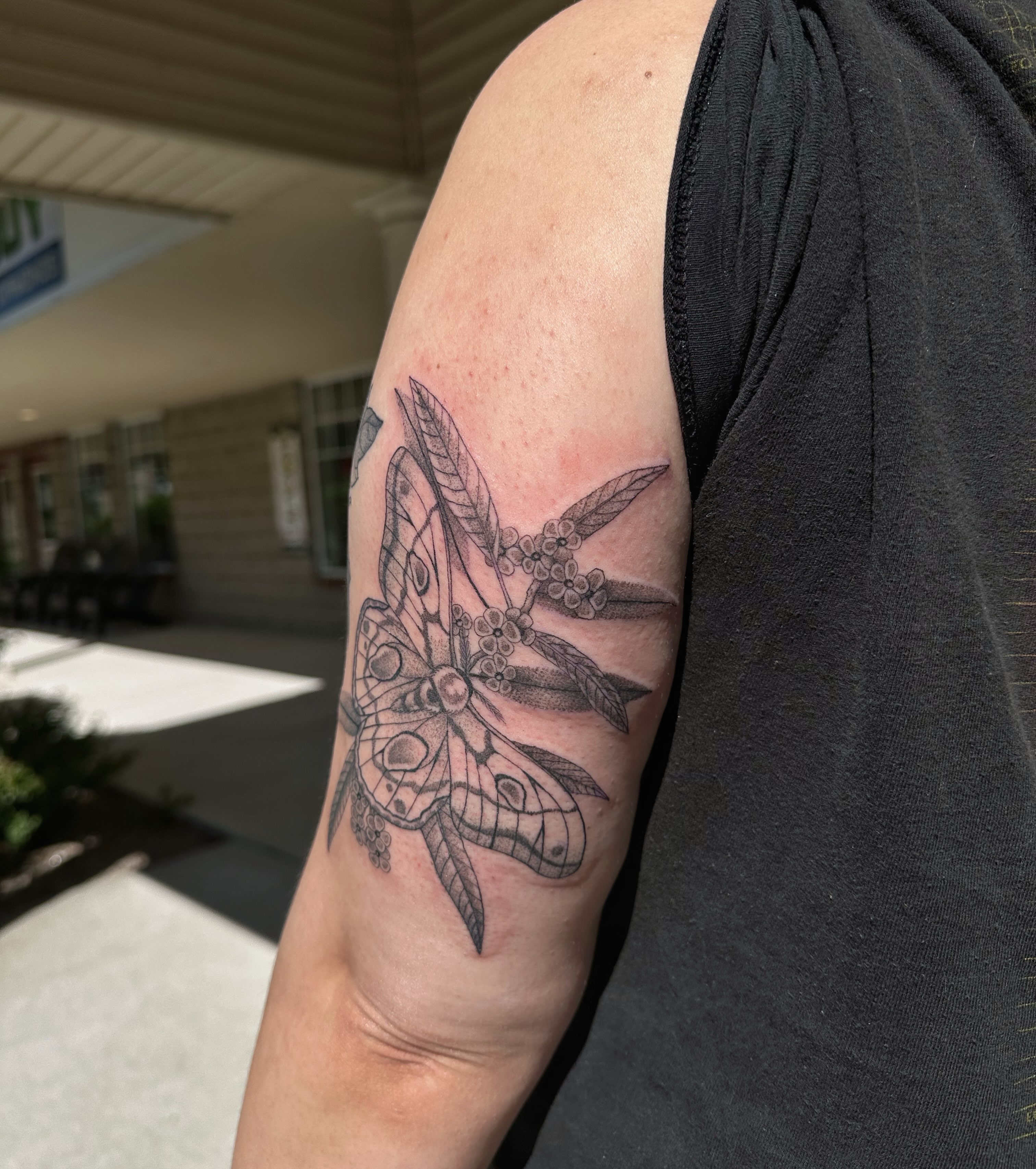 Moth and flowers black and grey tattoo on the forearm by J Valentin