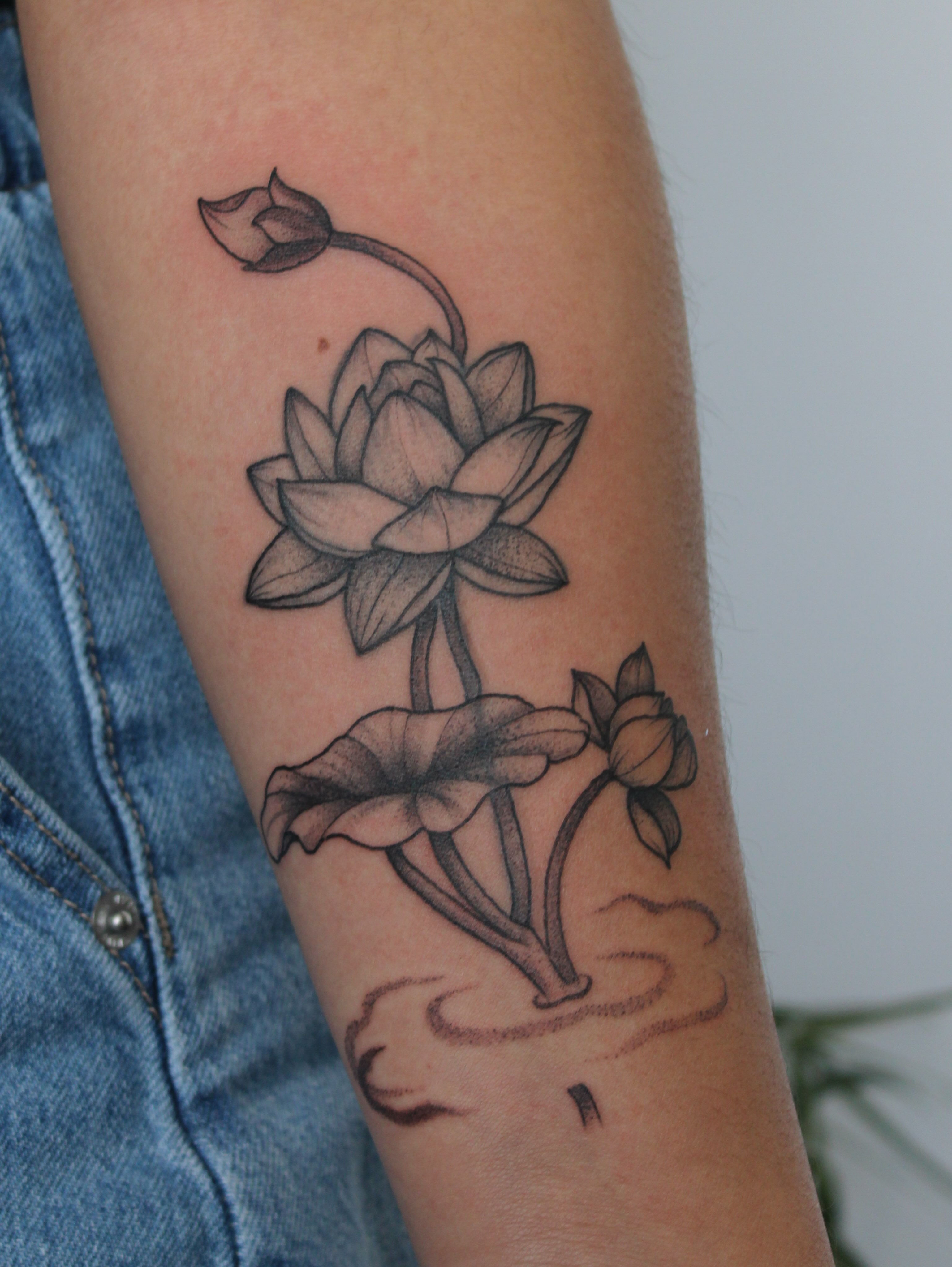 Lotus flower black and grey tattoo on the forearm by Julianna