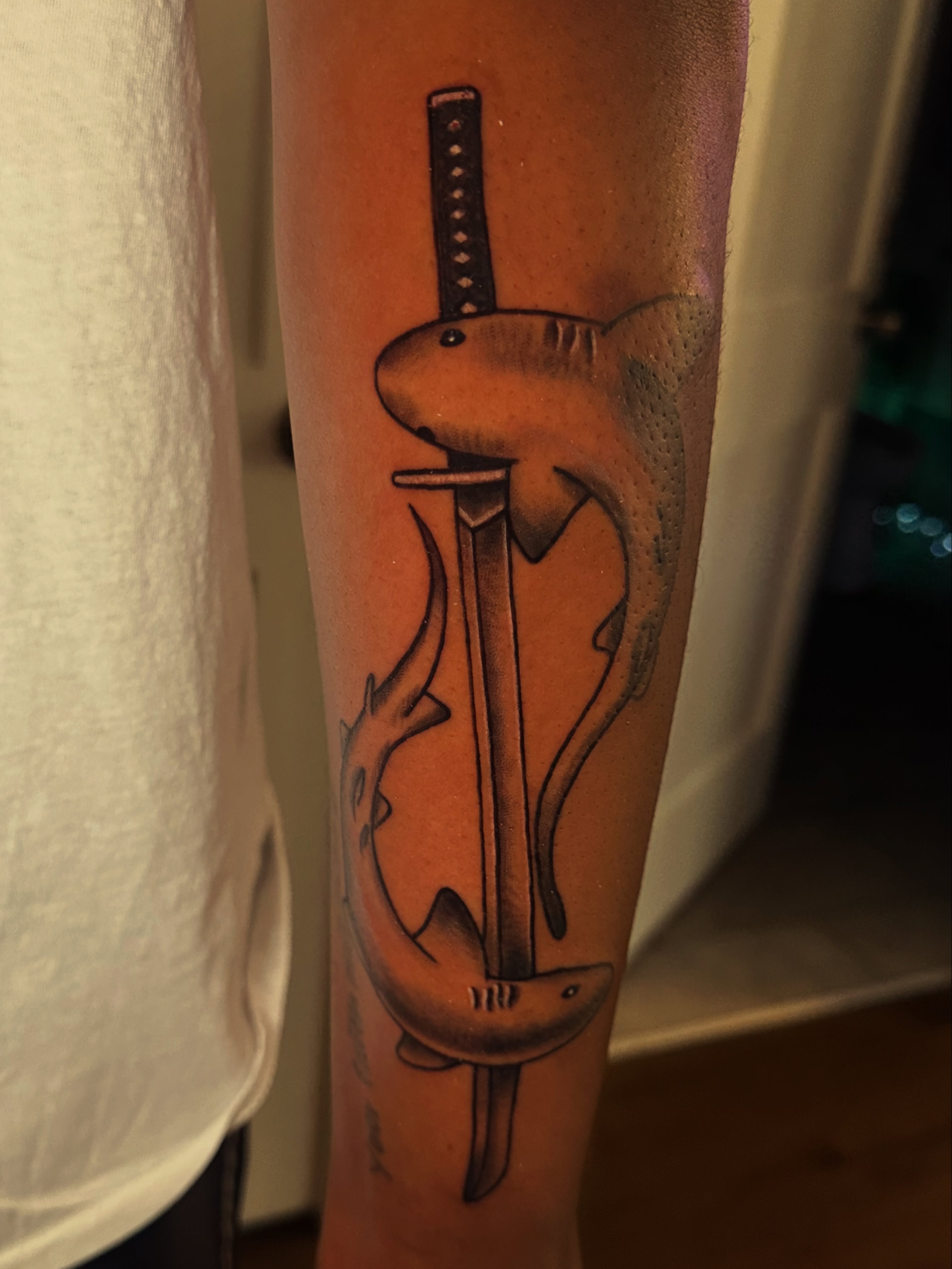 Shark and sword black and grey tattoo on the forearm by Drew’s Tattoos (NH)