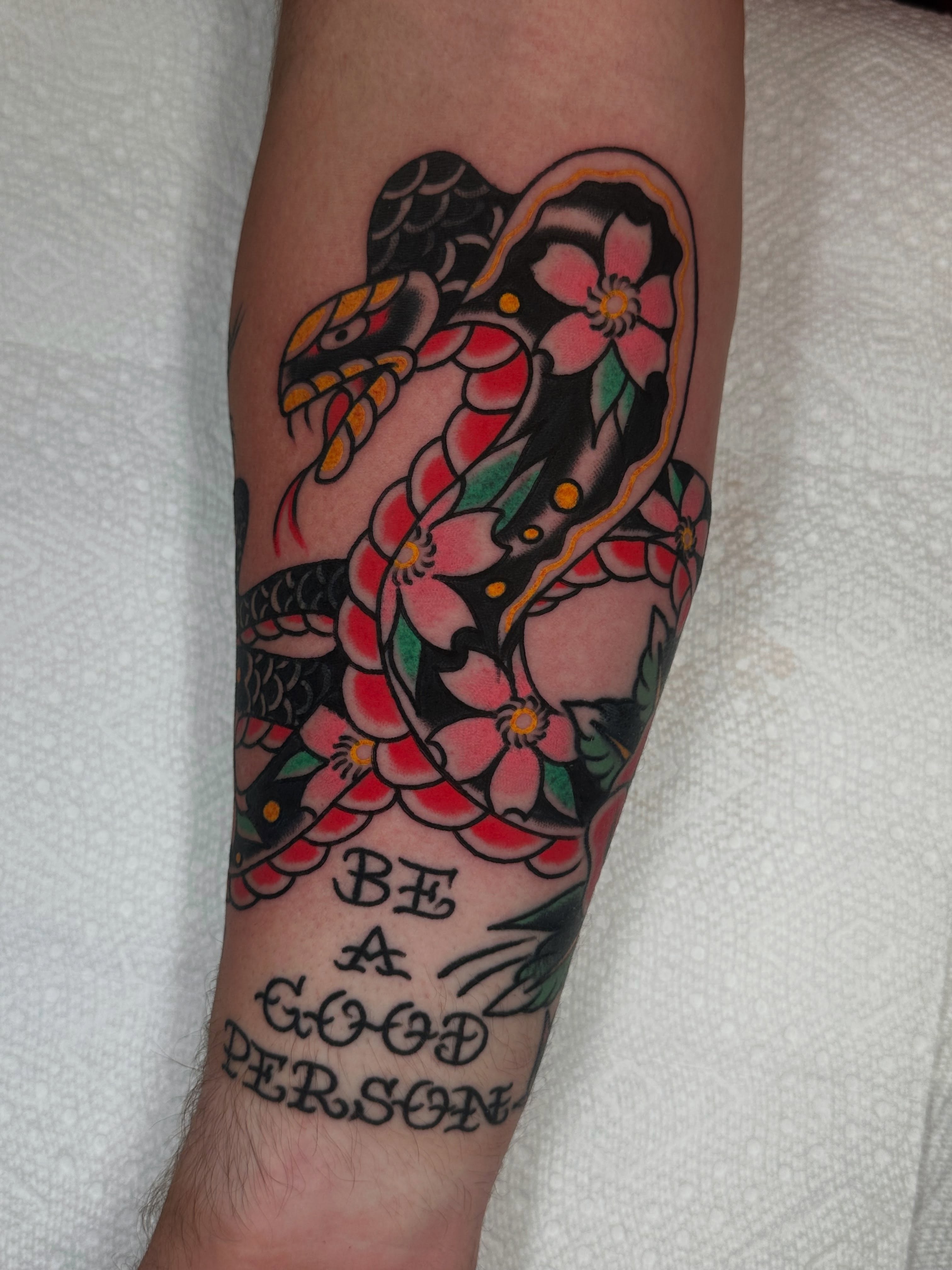 Snake and peony American traditional tattoo on the forearm by Spencer Crawford, Speedway, Indiana