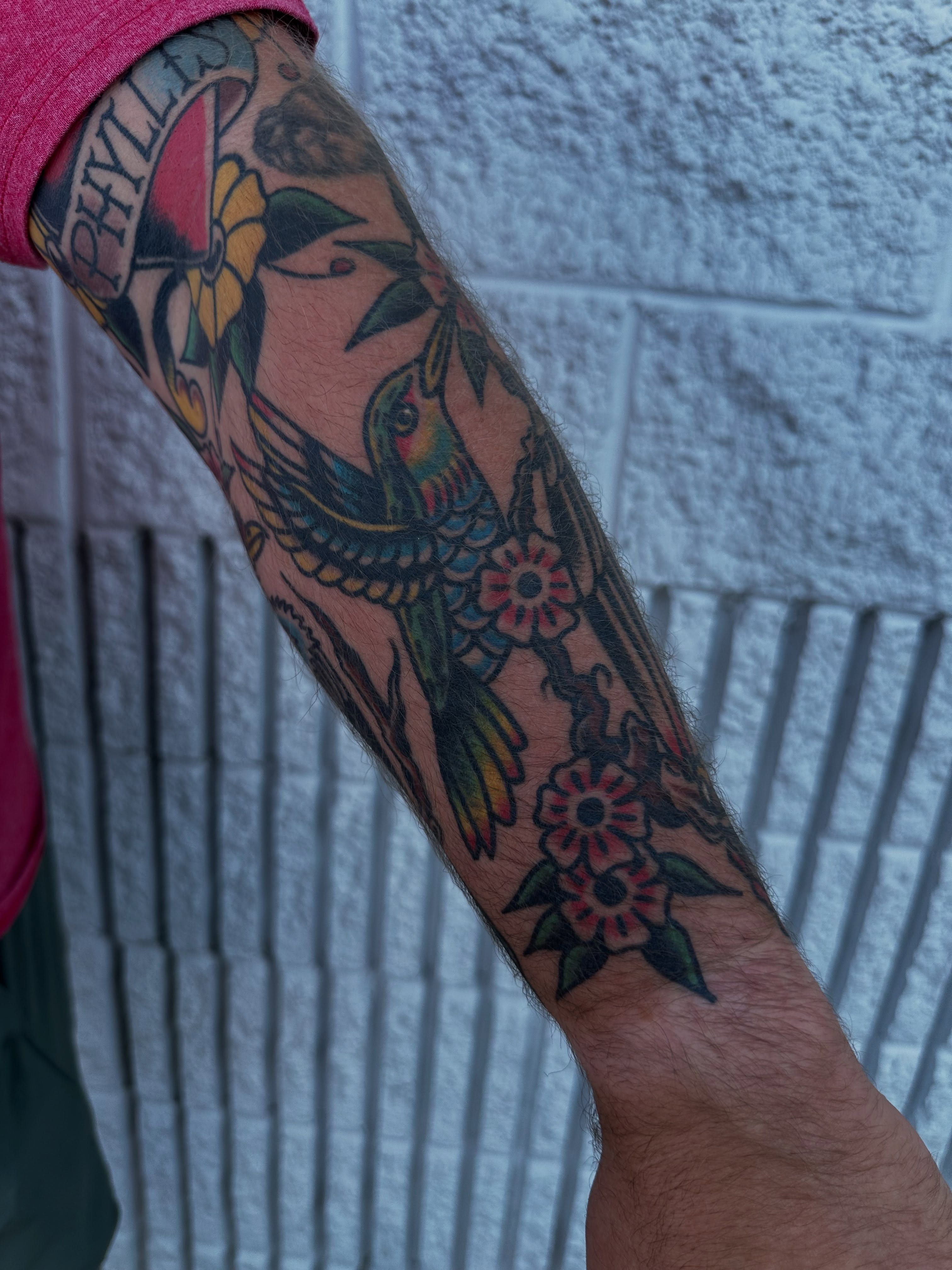 Hummingbird and flowers American traditional tattoo on the forearm by Spencer Crawford, Speedway, Indiana