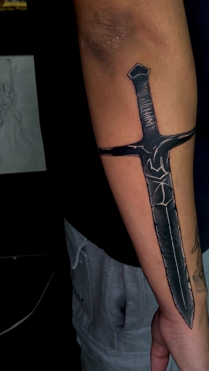 Sword cyber sigilism tattoo on the upper arm by Irving Guzman