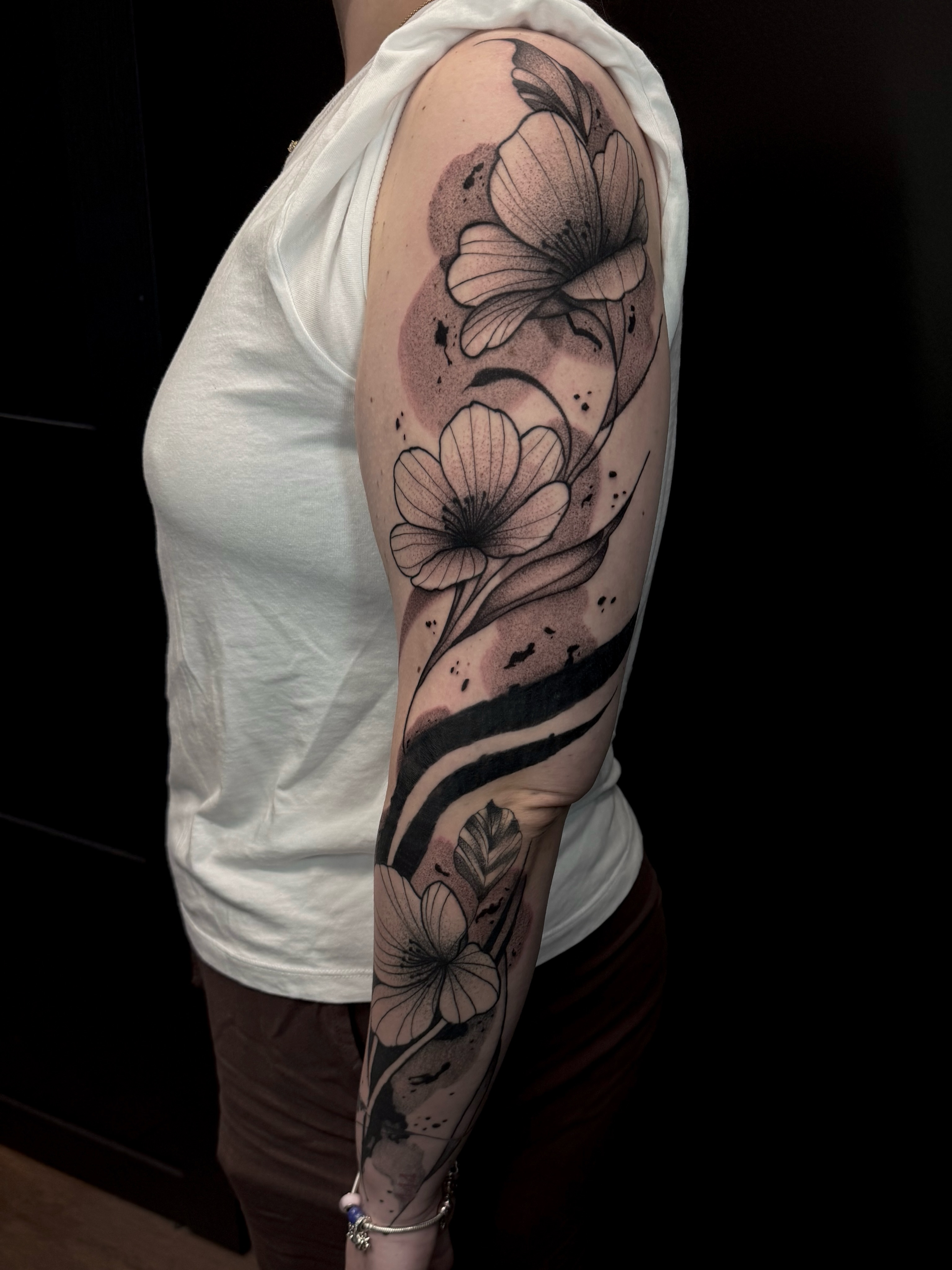 Flowers dotwork tattoo on the upper arm by Sebastián Vallejo
