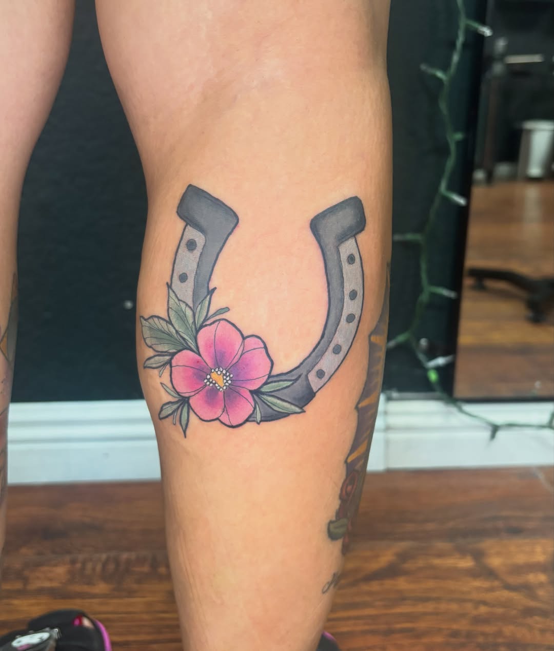 Horseshoe with flower American traditional tattoo on the forearm by Emma ๐